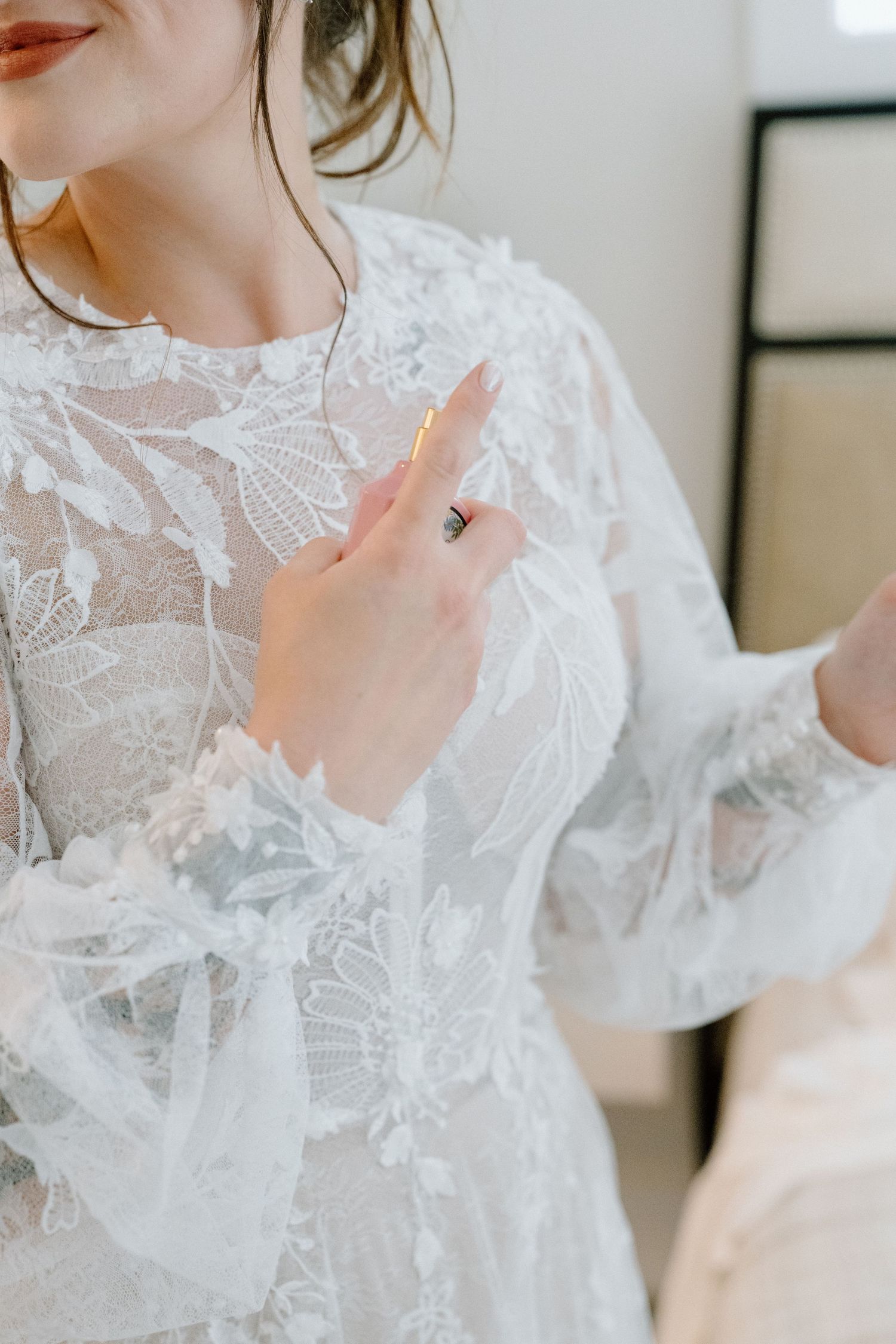 Close-up detail of intricate lace pattern on white wedding dress sleeve.