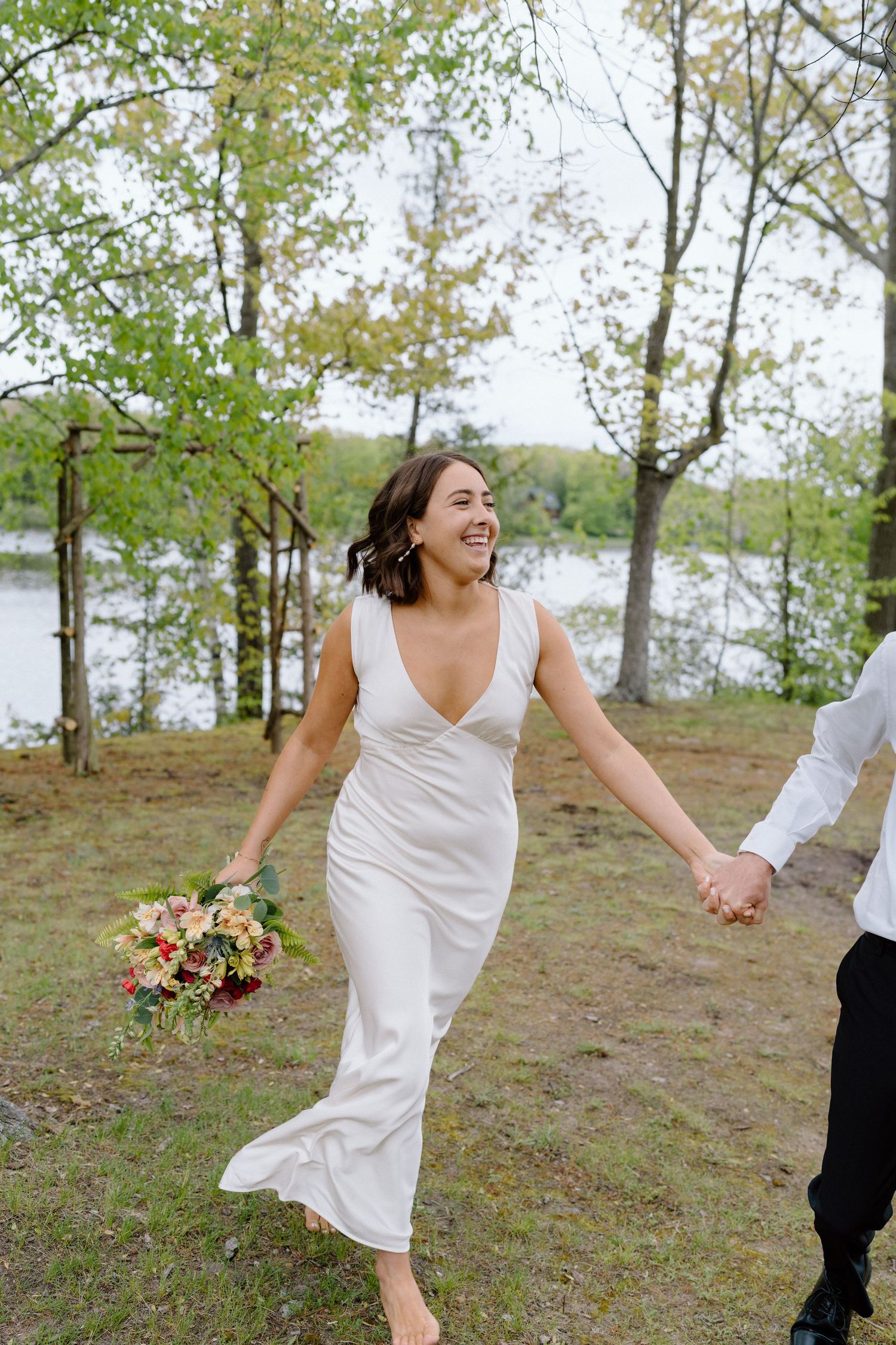 Joyful wedding sequence captured on hill overlooking tranquil lake.