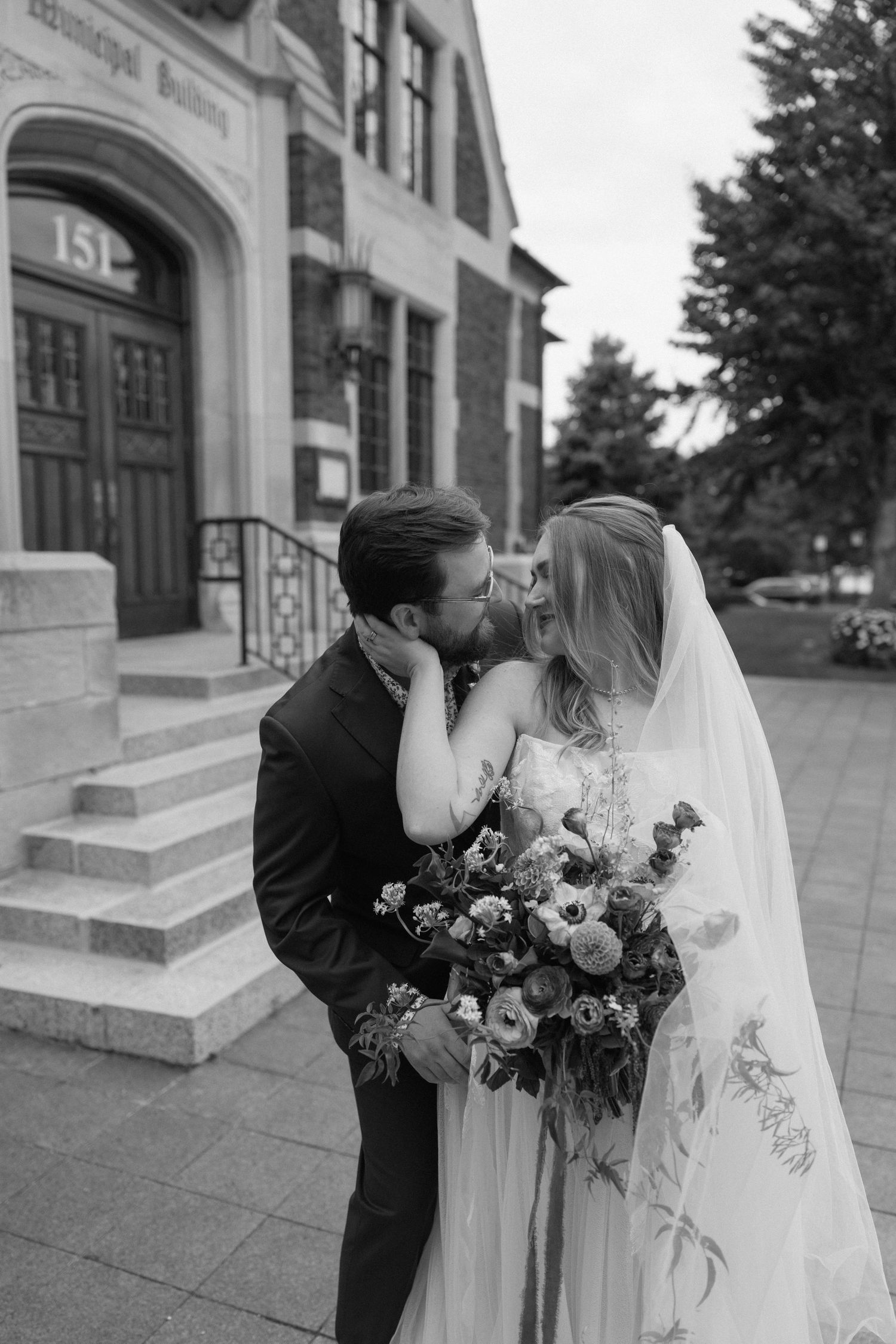 Black and white wedding photo series showing romantic moments between newlyweds with a beautiful floral bouquet.