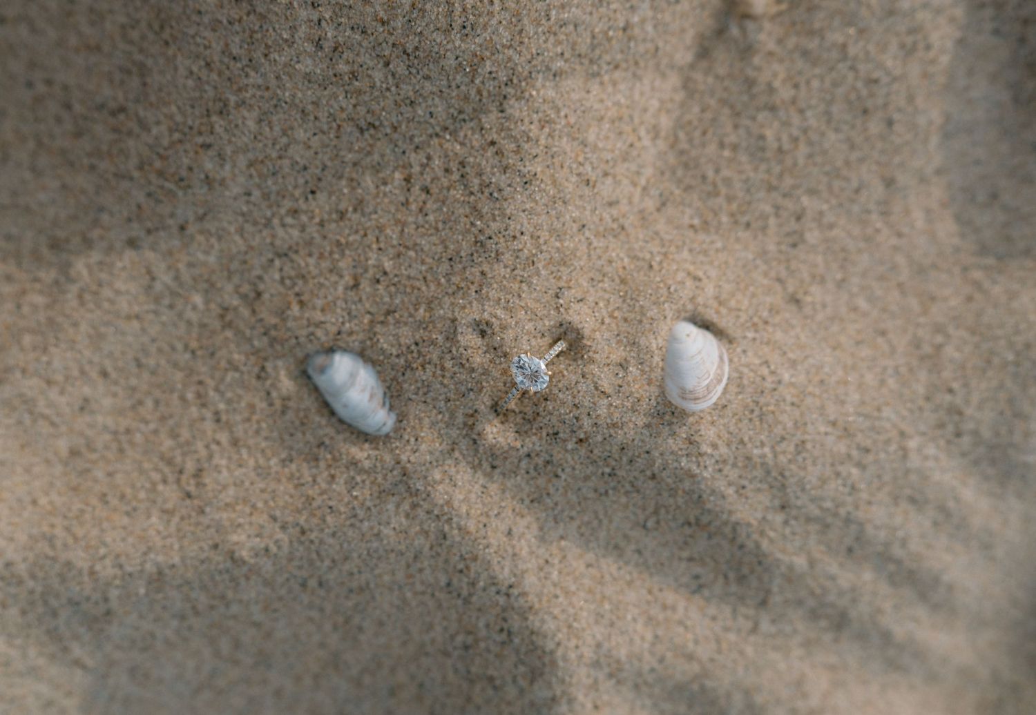 Close-up textured photograph of footprints in soft beige sand.