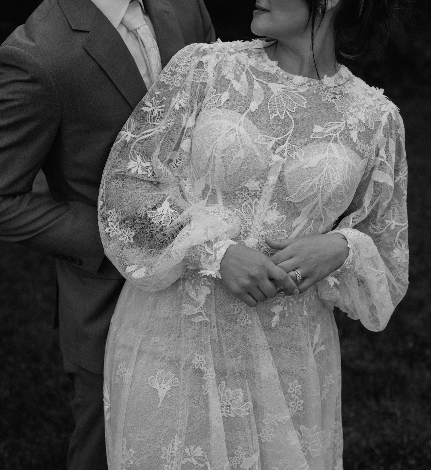 Close-up of intricate lace details on a flowing white wedding gown.