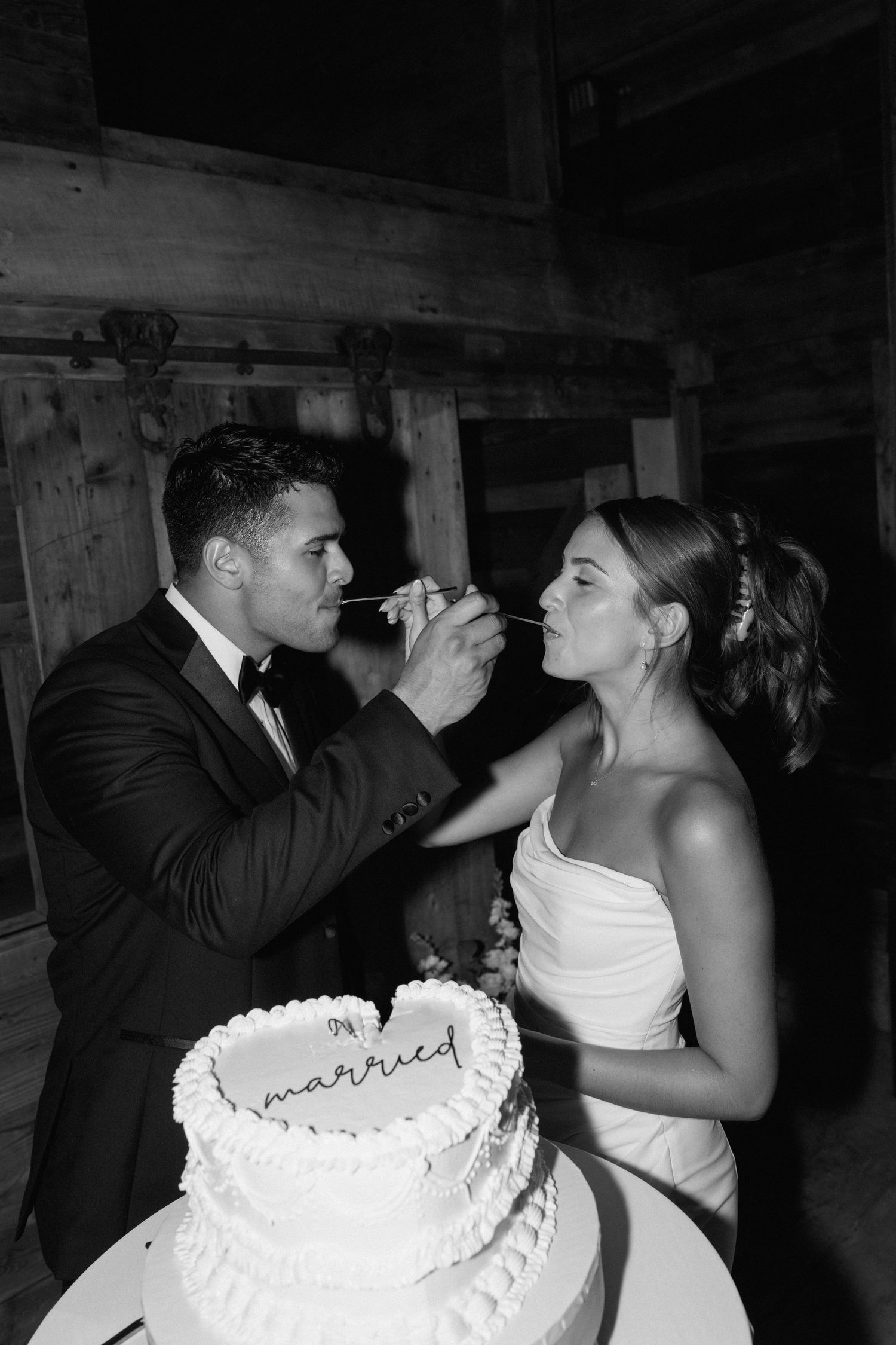 Newlyweds share cake during traditional wedding reception moment.