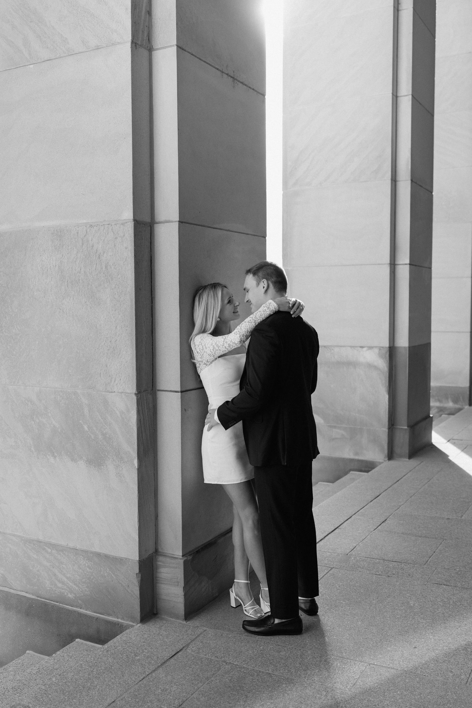 A black and white photo series showing a person in a suit looking behind columns in a repeating pattern.