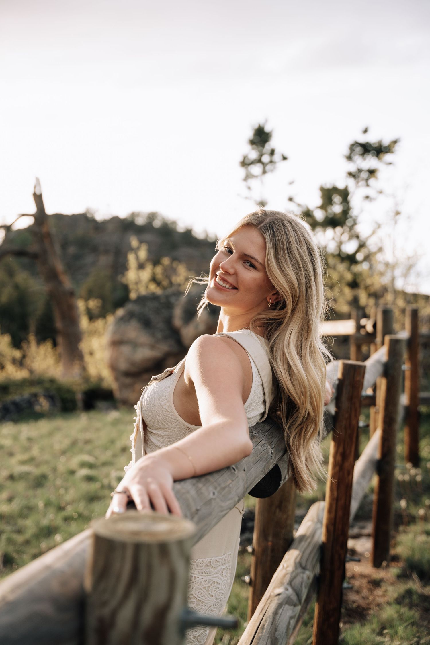 Girl posing on a fence for a photo.