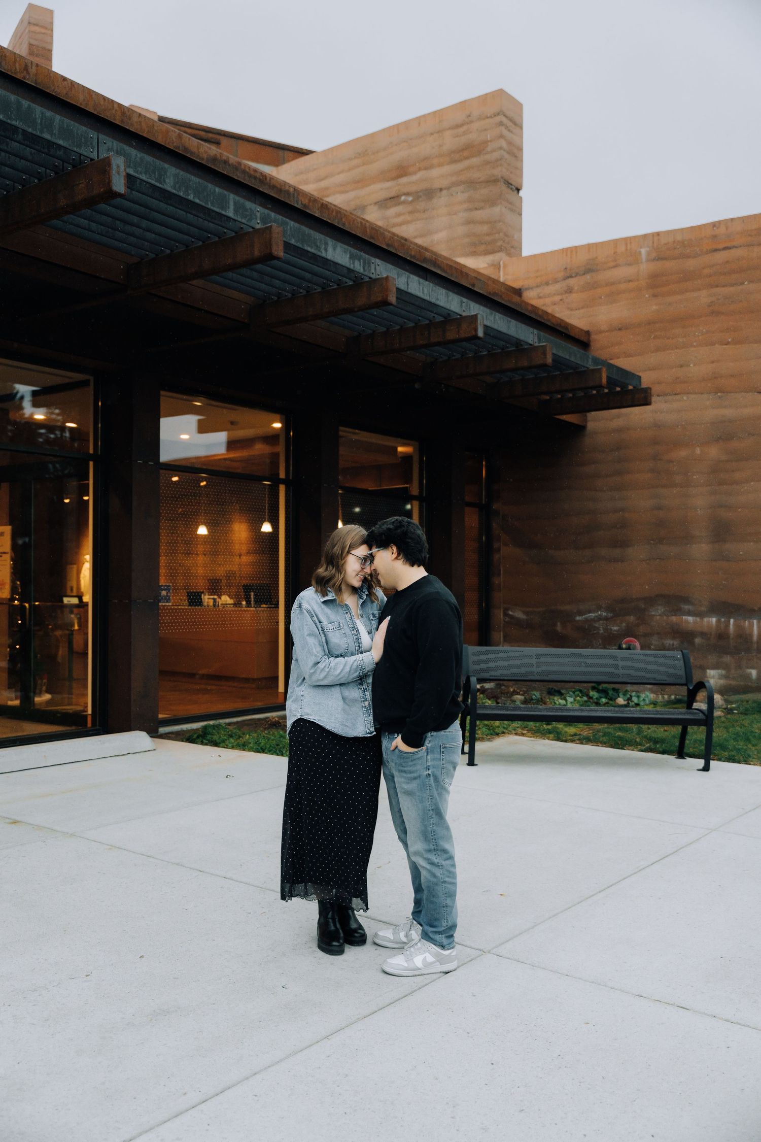 Girlfriend posing with boyfriend in front of museum