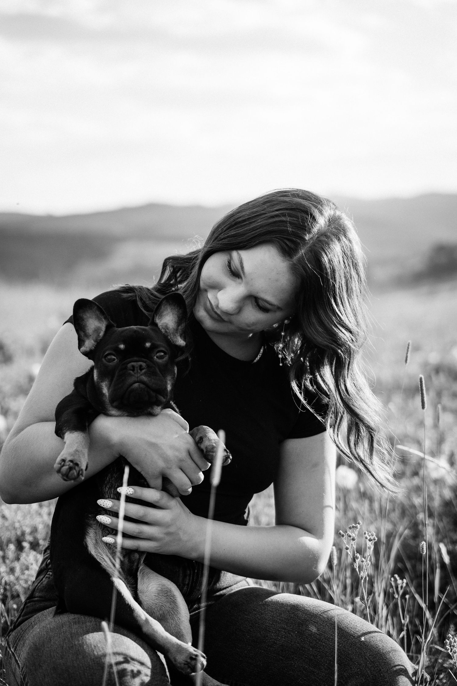 Girl Holding dog on her lap in a field of flowers