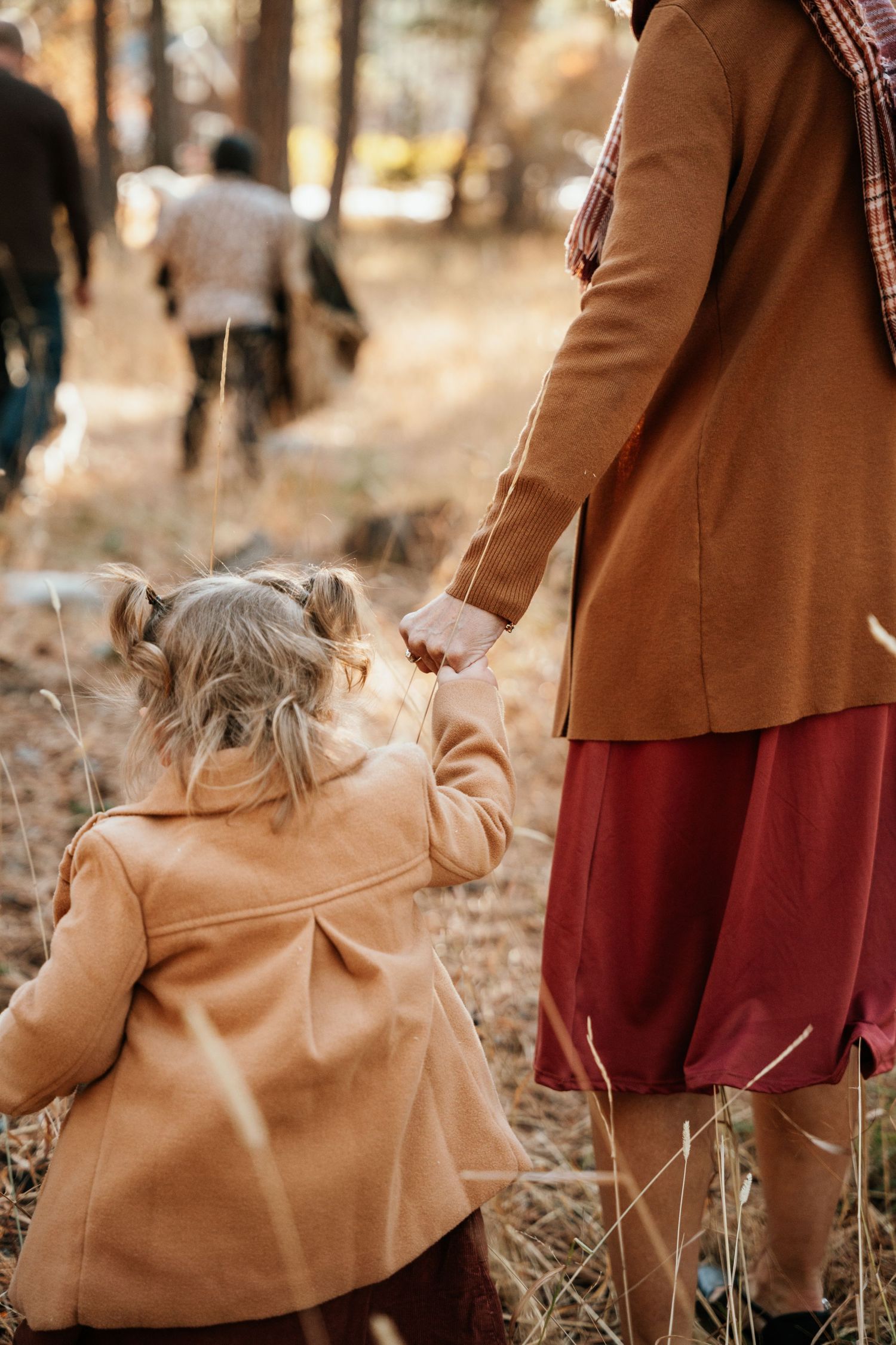 candid photo of grandma helping granddaughter walk.