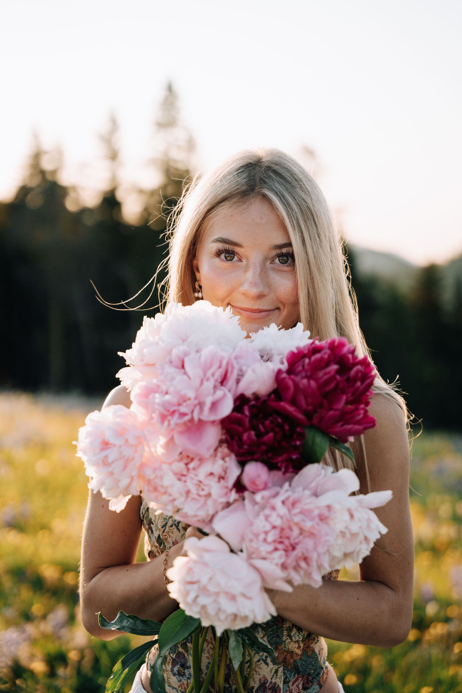Girl Holding flowers in front of her while looking at the camera.