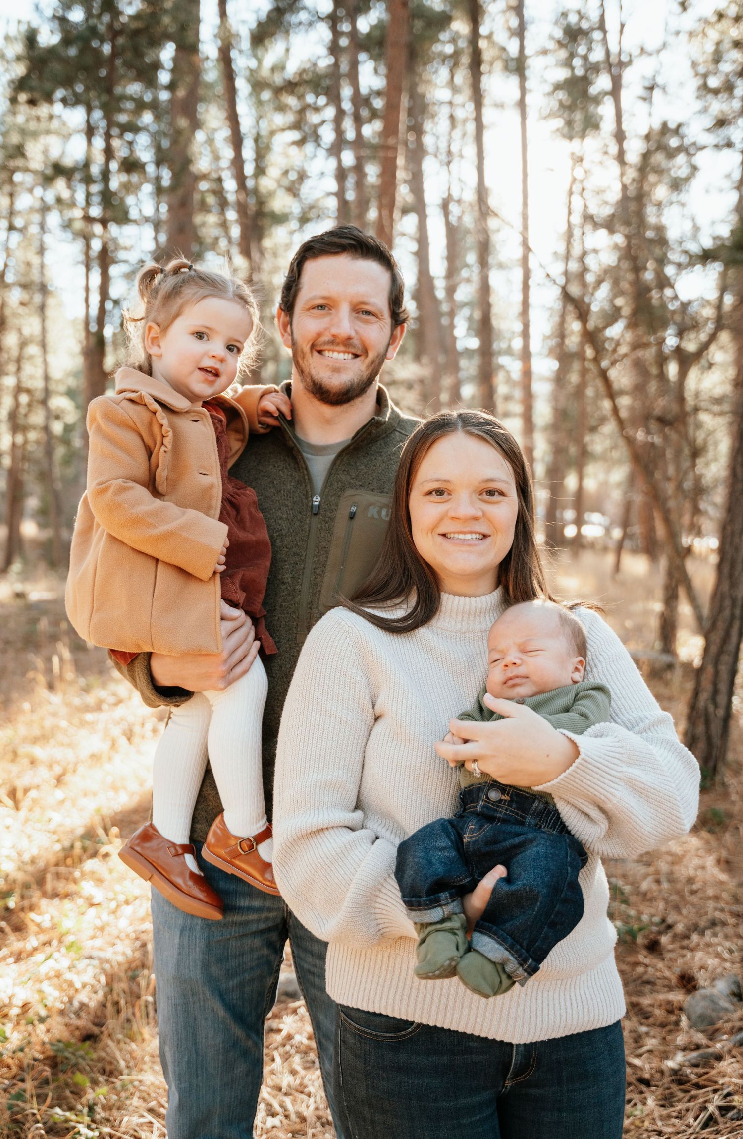 Mother, father, son, and daughter posing and looking at camera.