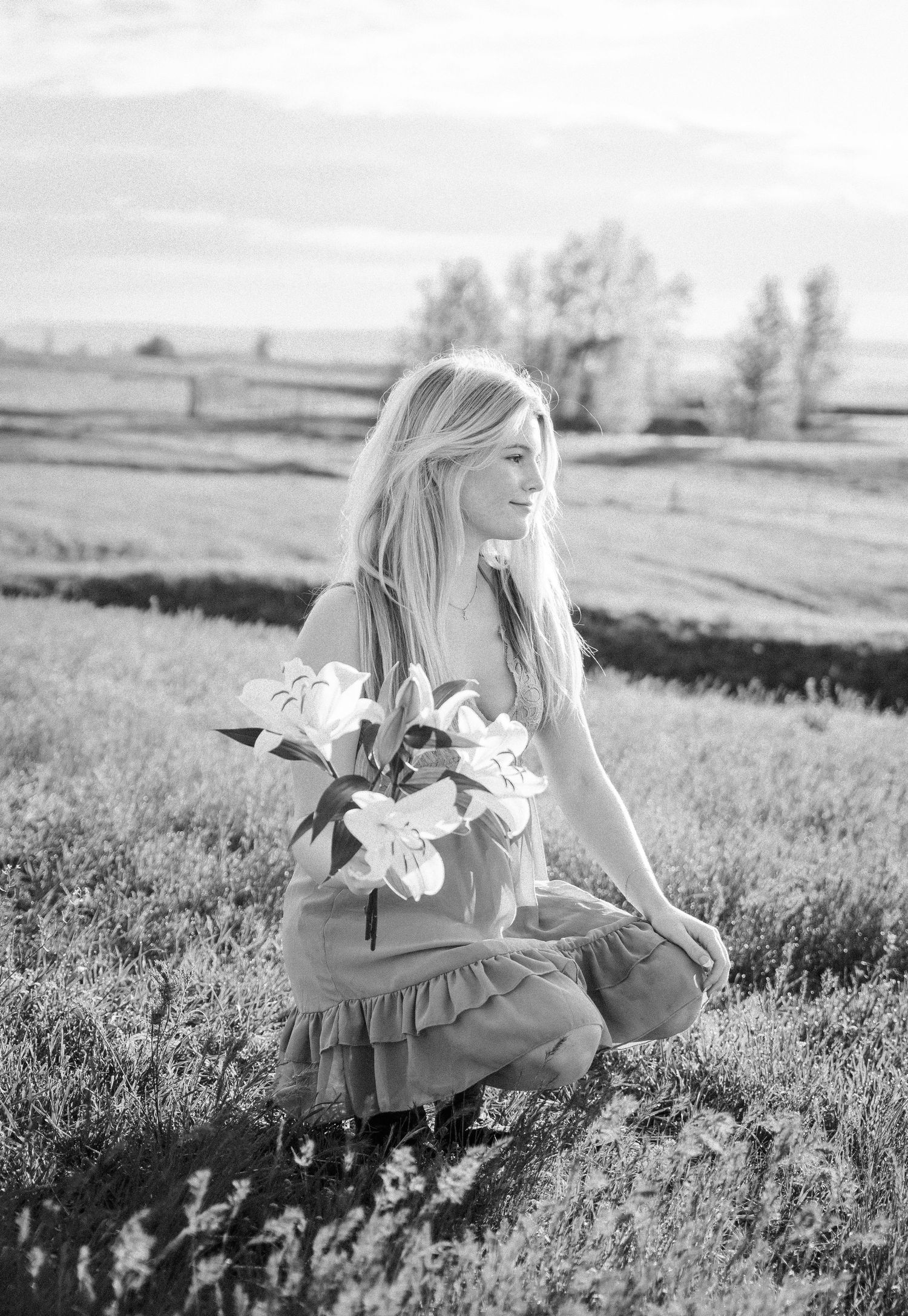 Girl holding a bouquet of flowers in a field.