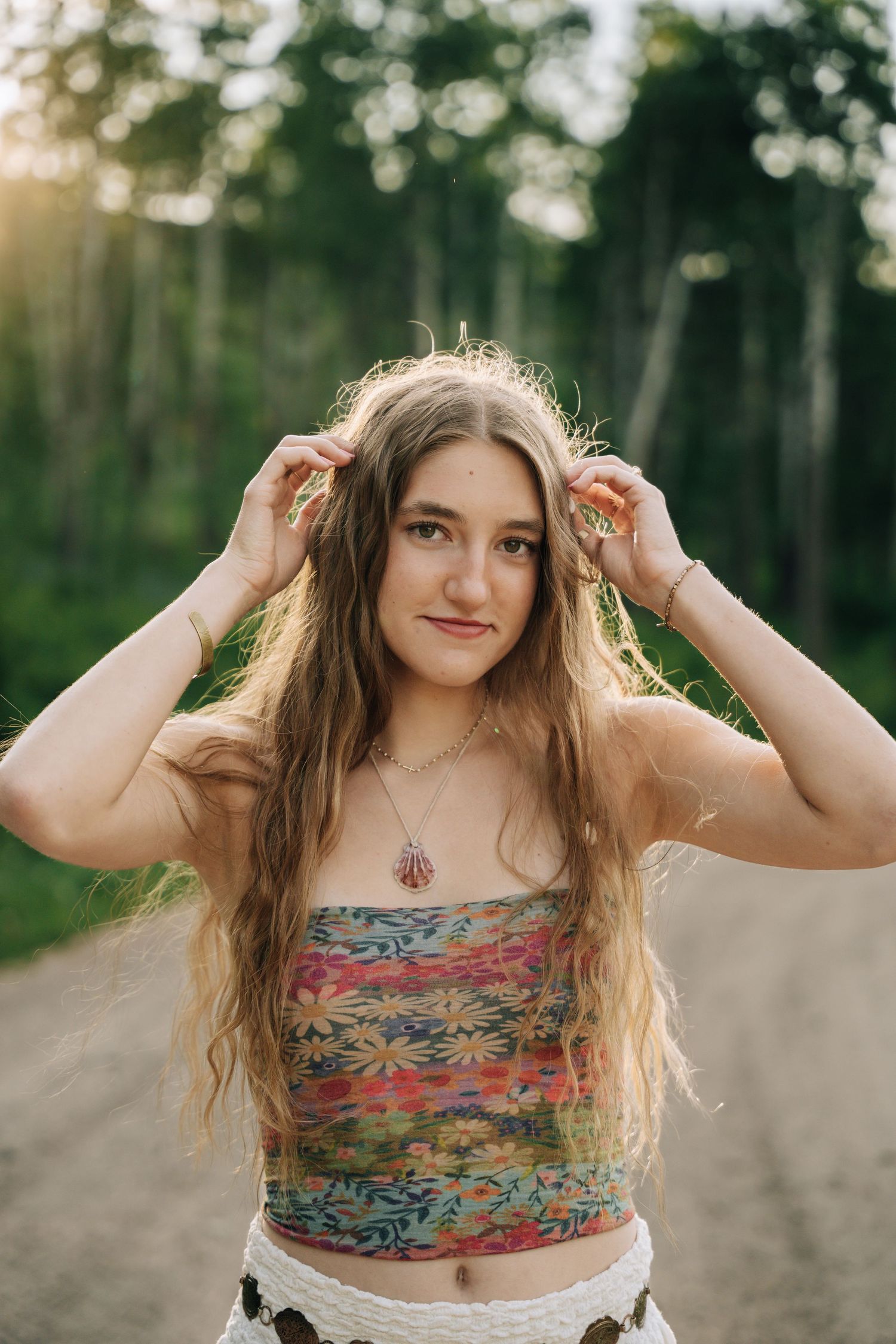 Senior posing with hands in her hair.