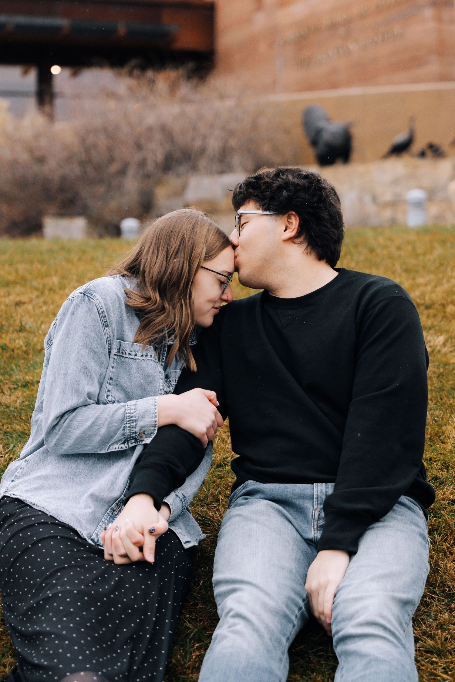 Boyfriend kissing girlfriend on forehead.