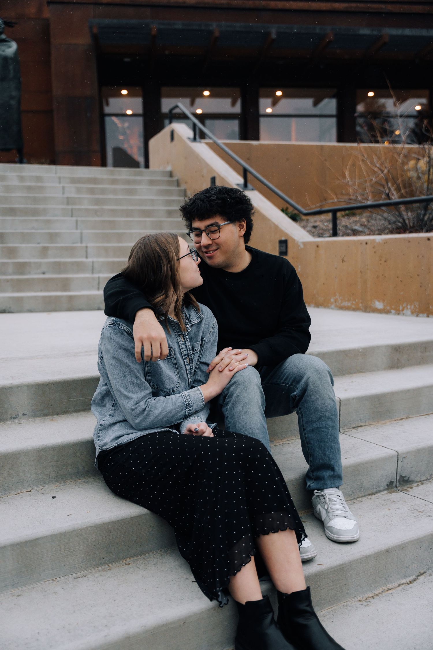 Girlfriend posing with boyfriend in front of museum