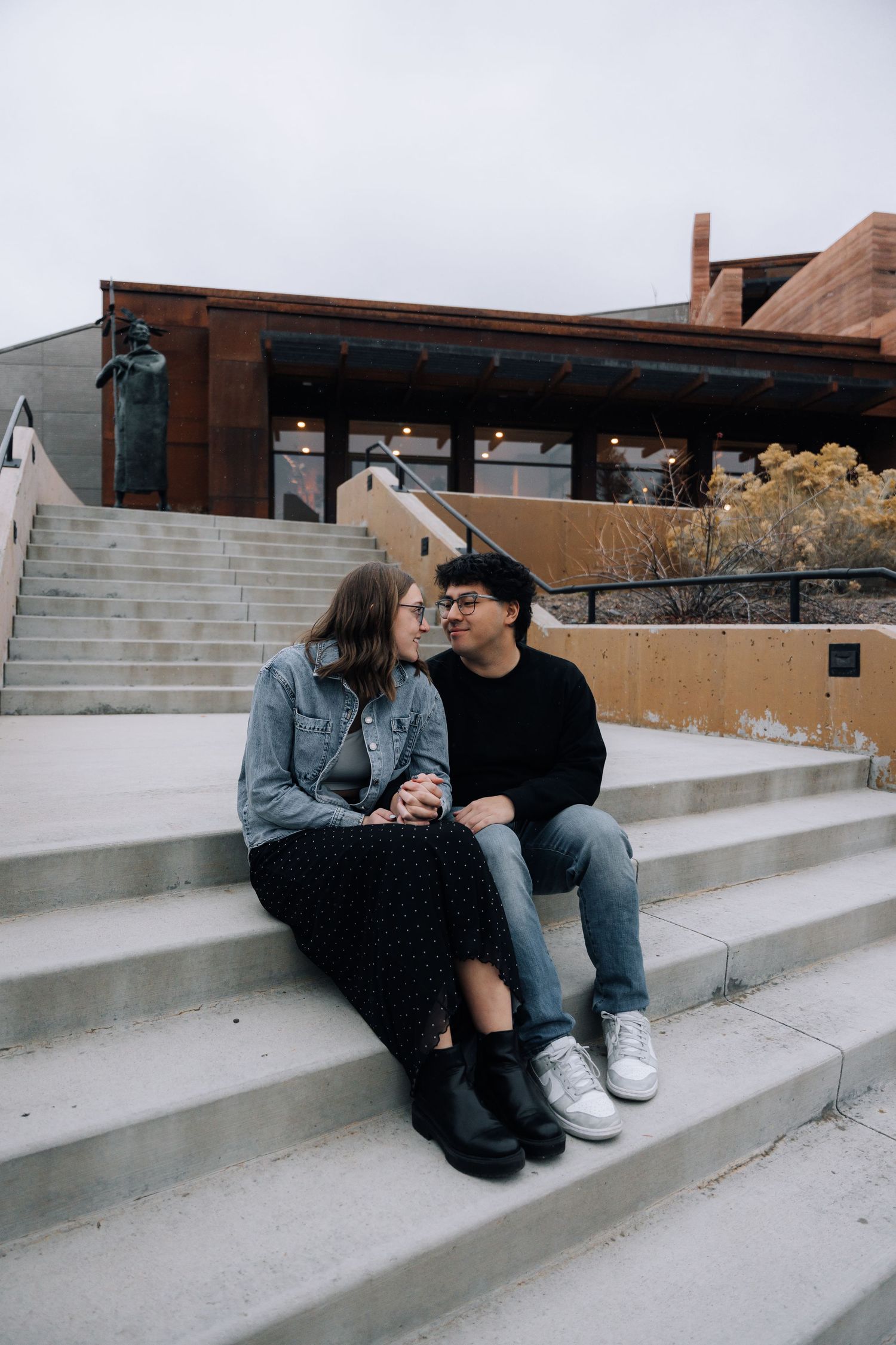 Girlfriend posing with boyfriend in front of museum