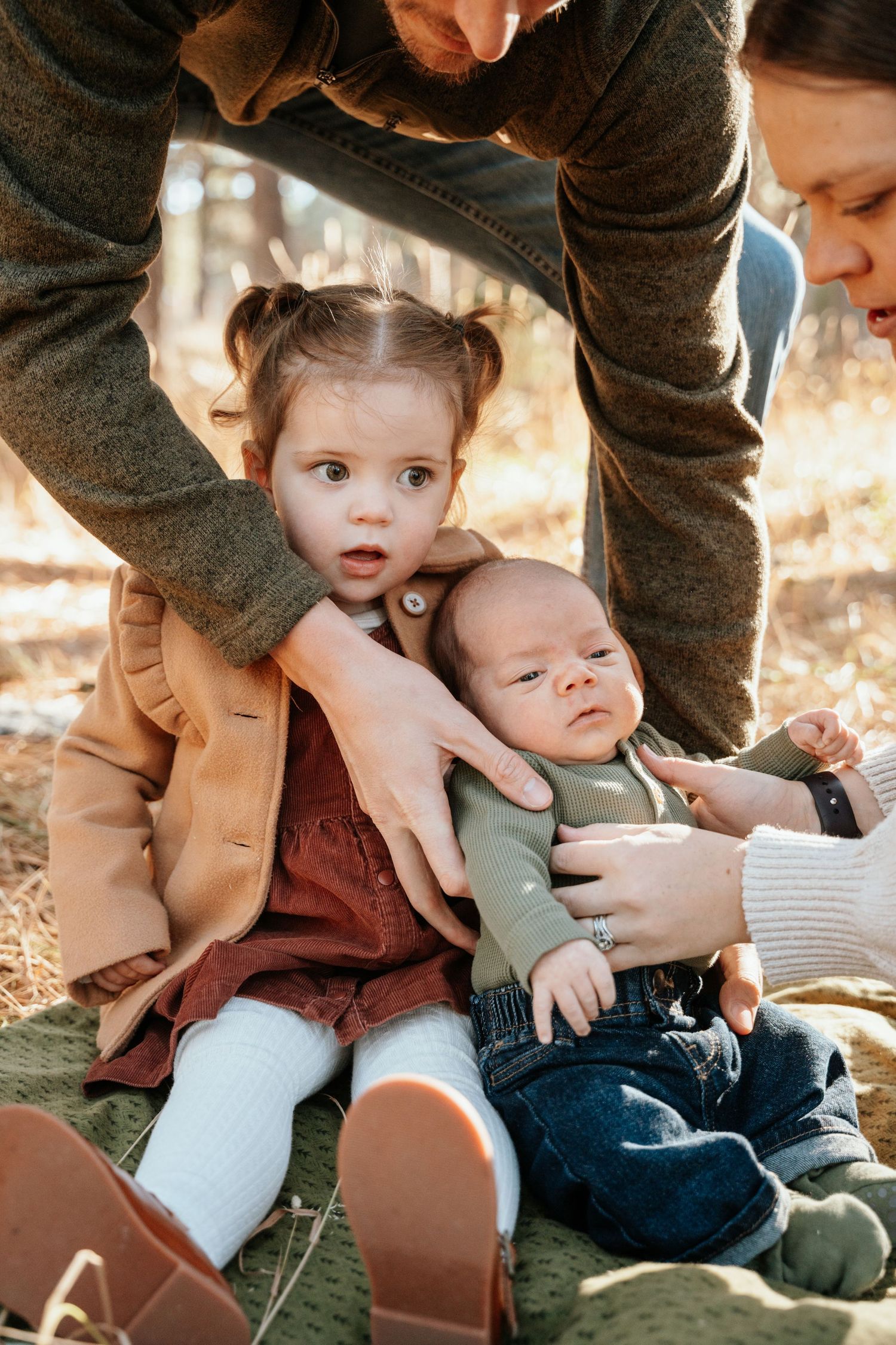 candid moment of dad helping pose his young children.