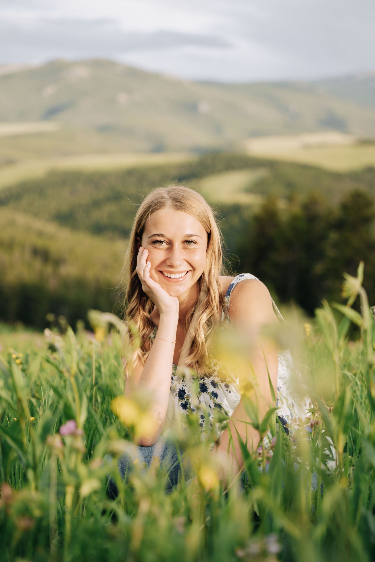 Girl sitting with her head in her hands in a flower field