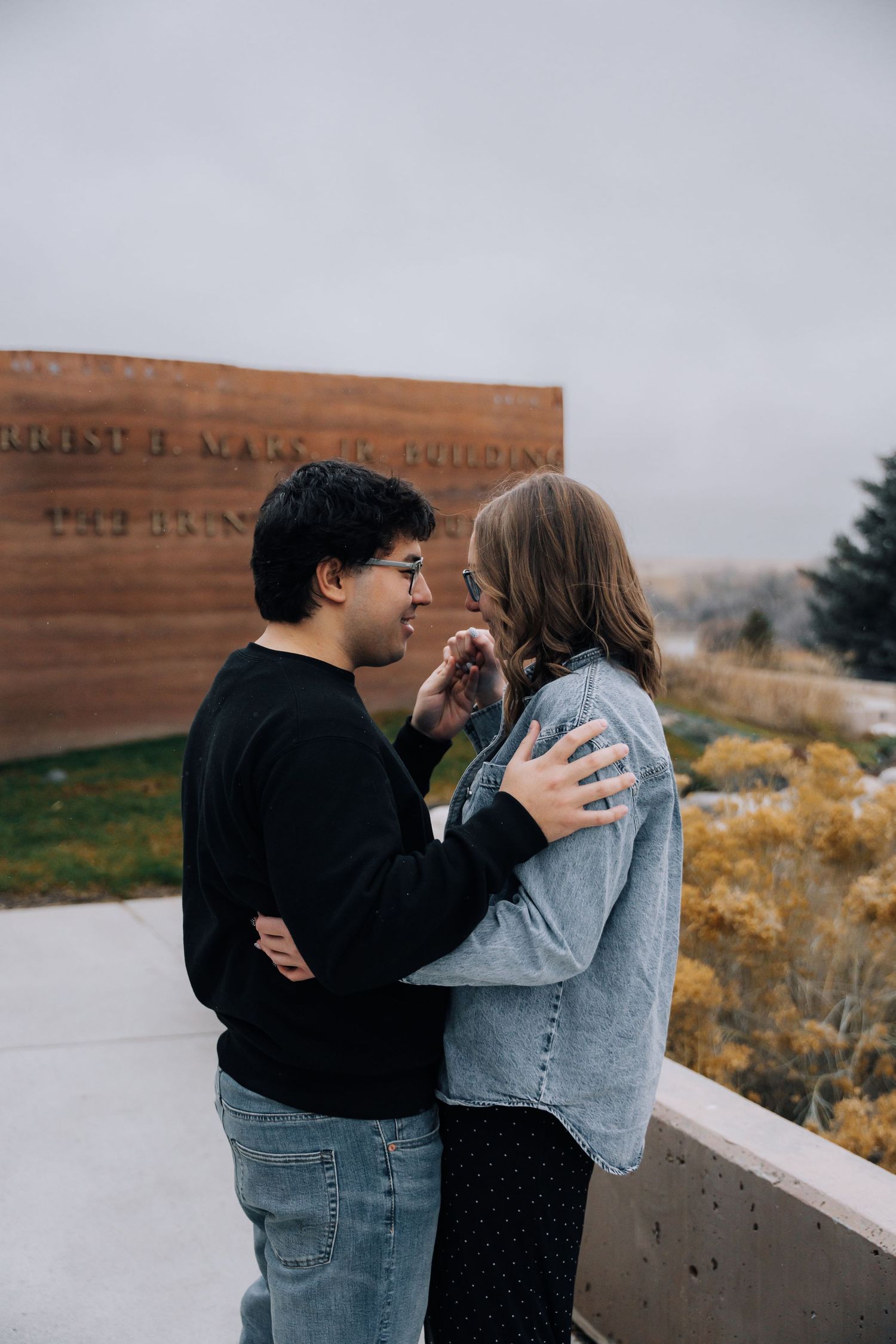 Girlfriend posing with boyfriend in front of museum