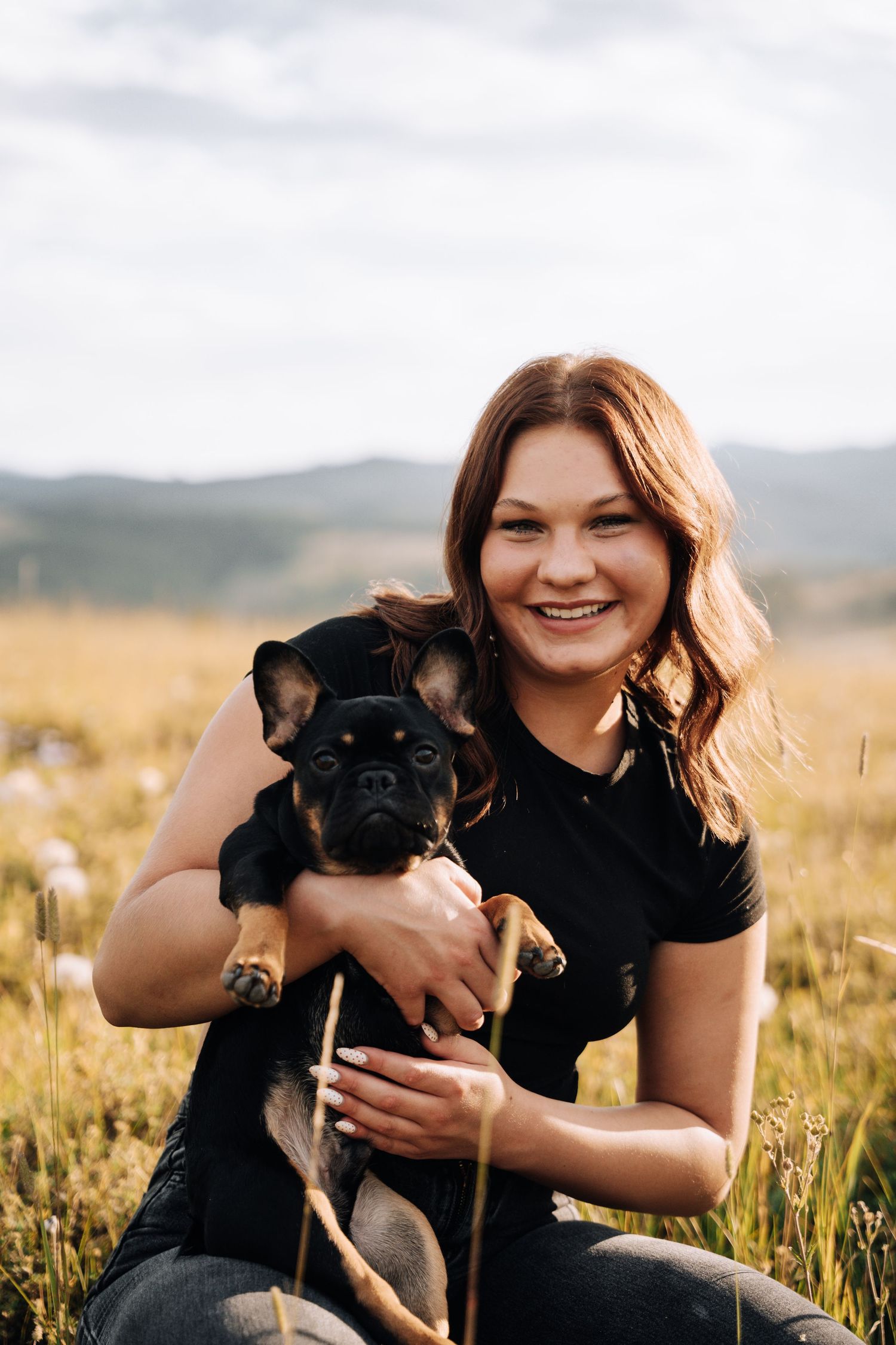 Girl Holding dog on her lap in a field of flowers