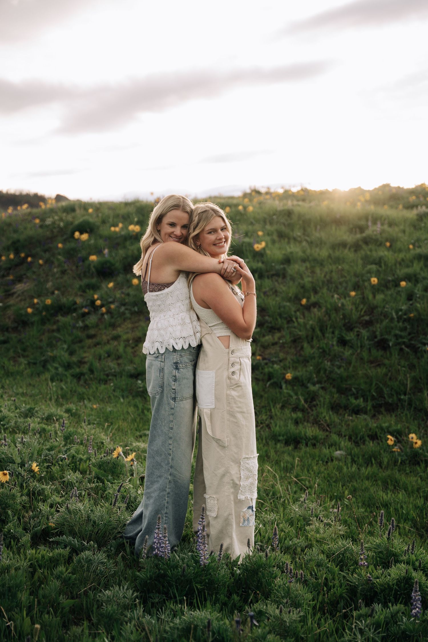 Girl posing with mom on a hill.