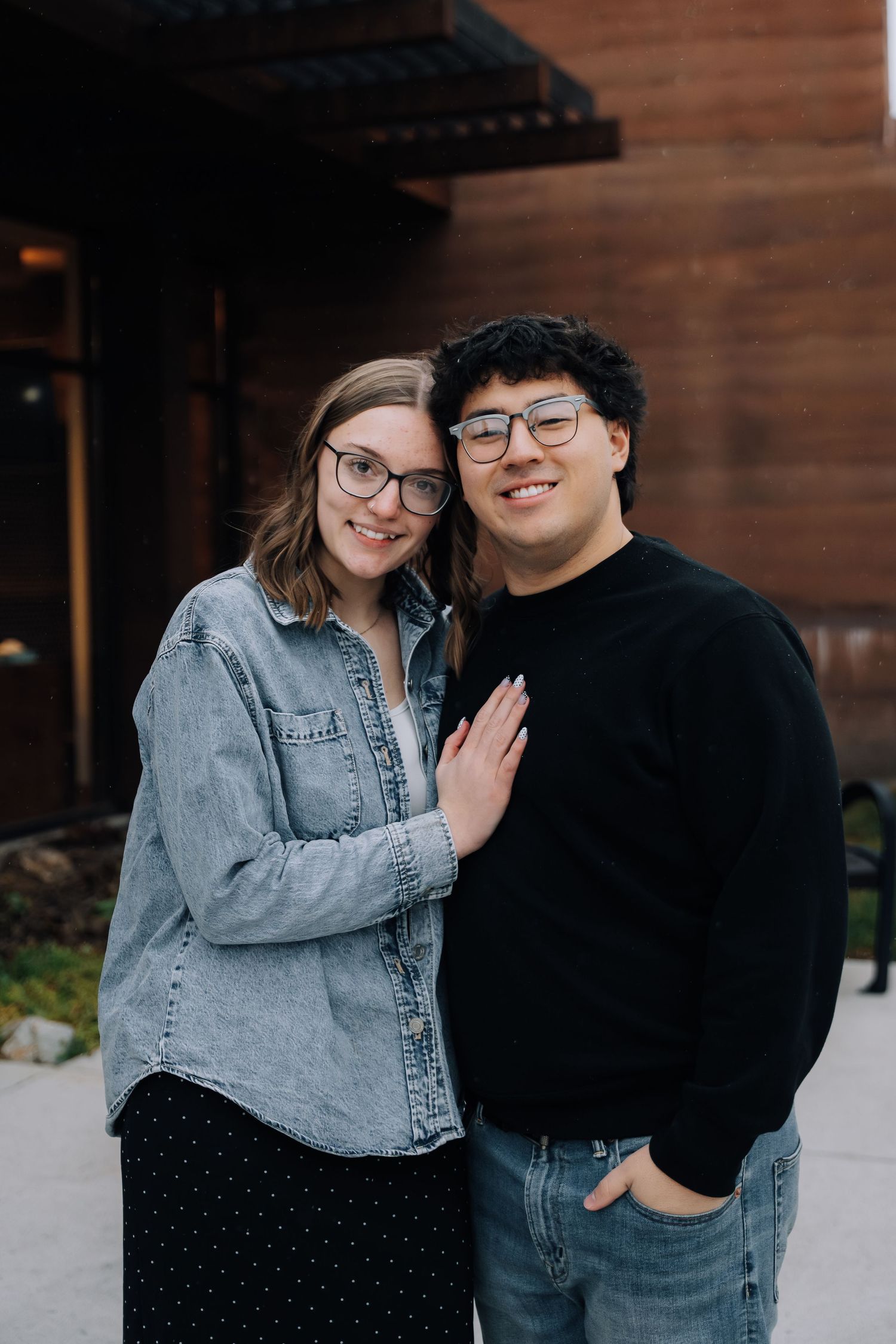 Girlfriend posing with boyfriend in front of museum
