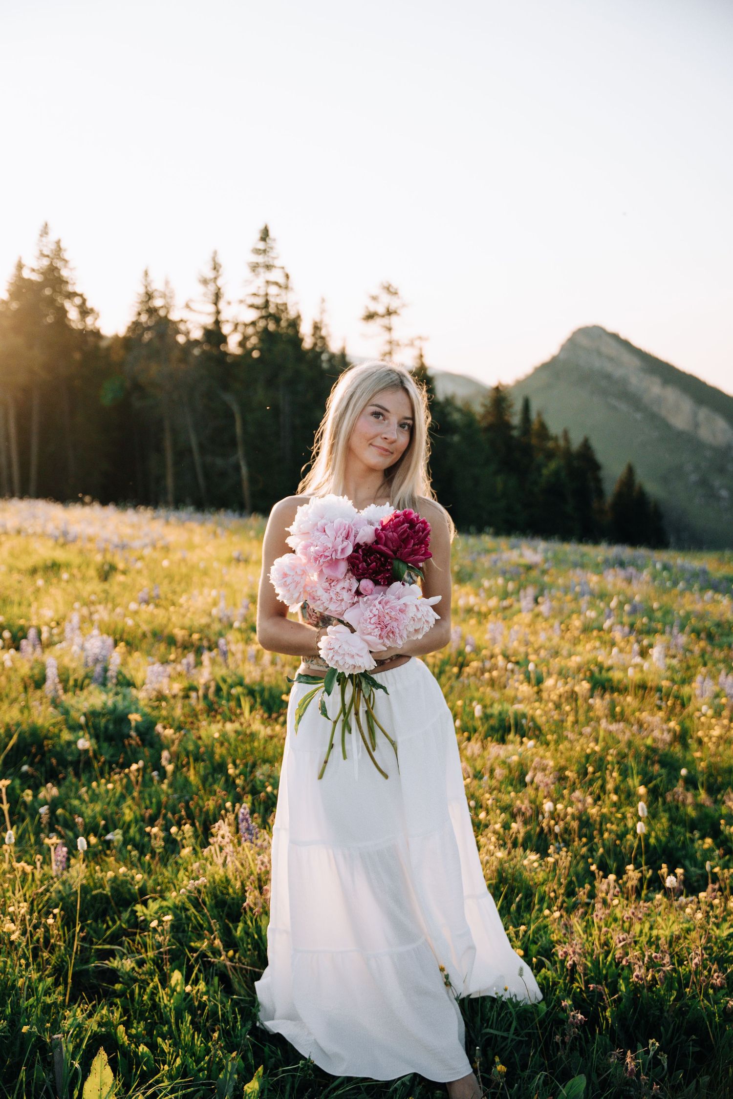 Girl Holding flowers in front of her while looking at the camera.