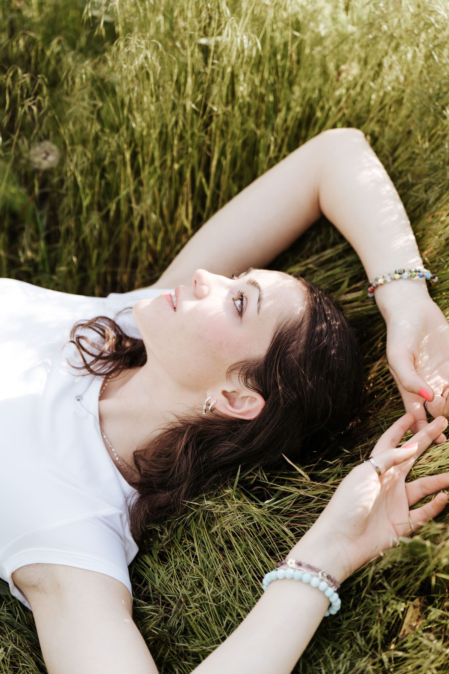 Girl laying in the grass, camera angle is directly above her.