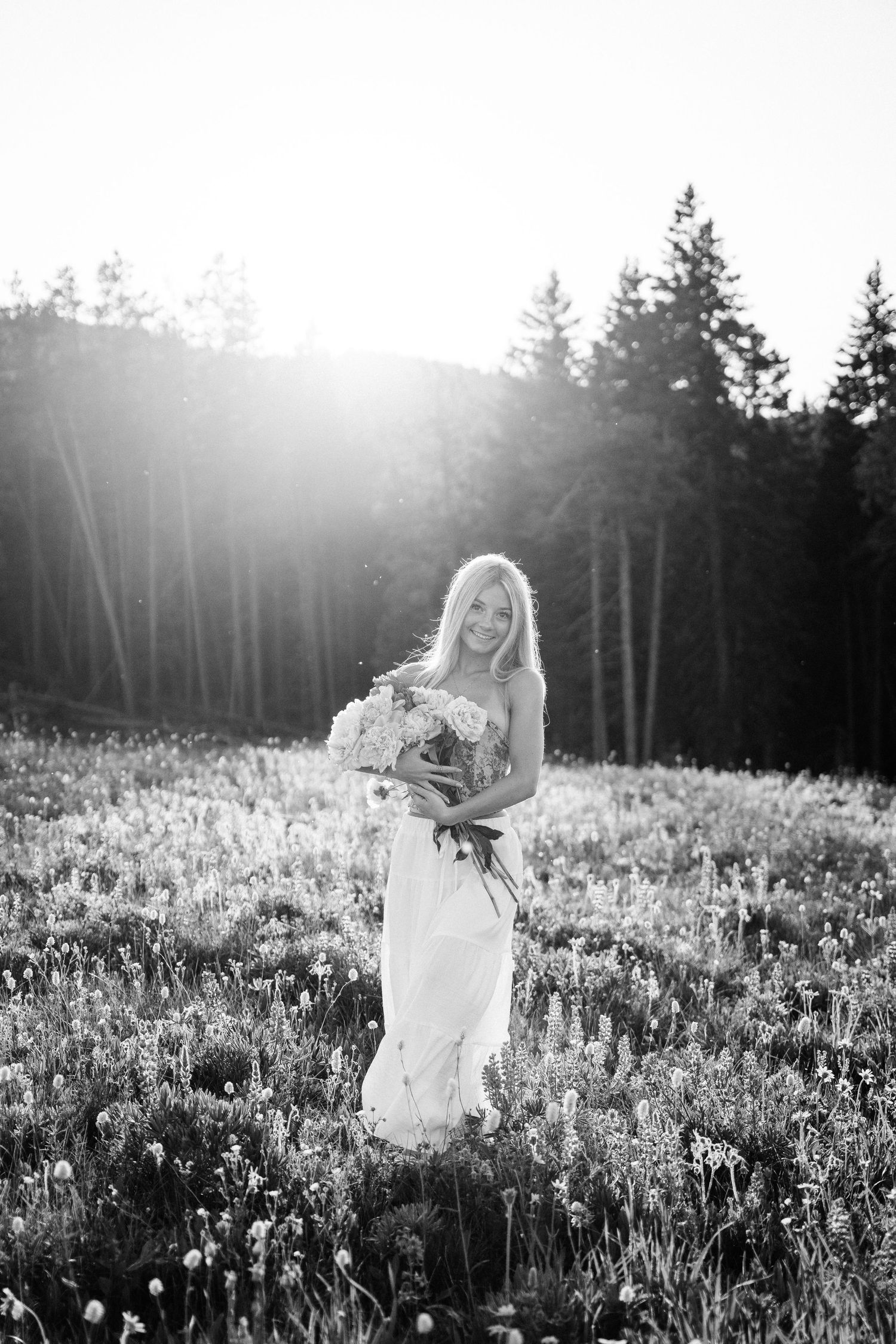 Girl Holding flowers in front of her while looking at the camera.