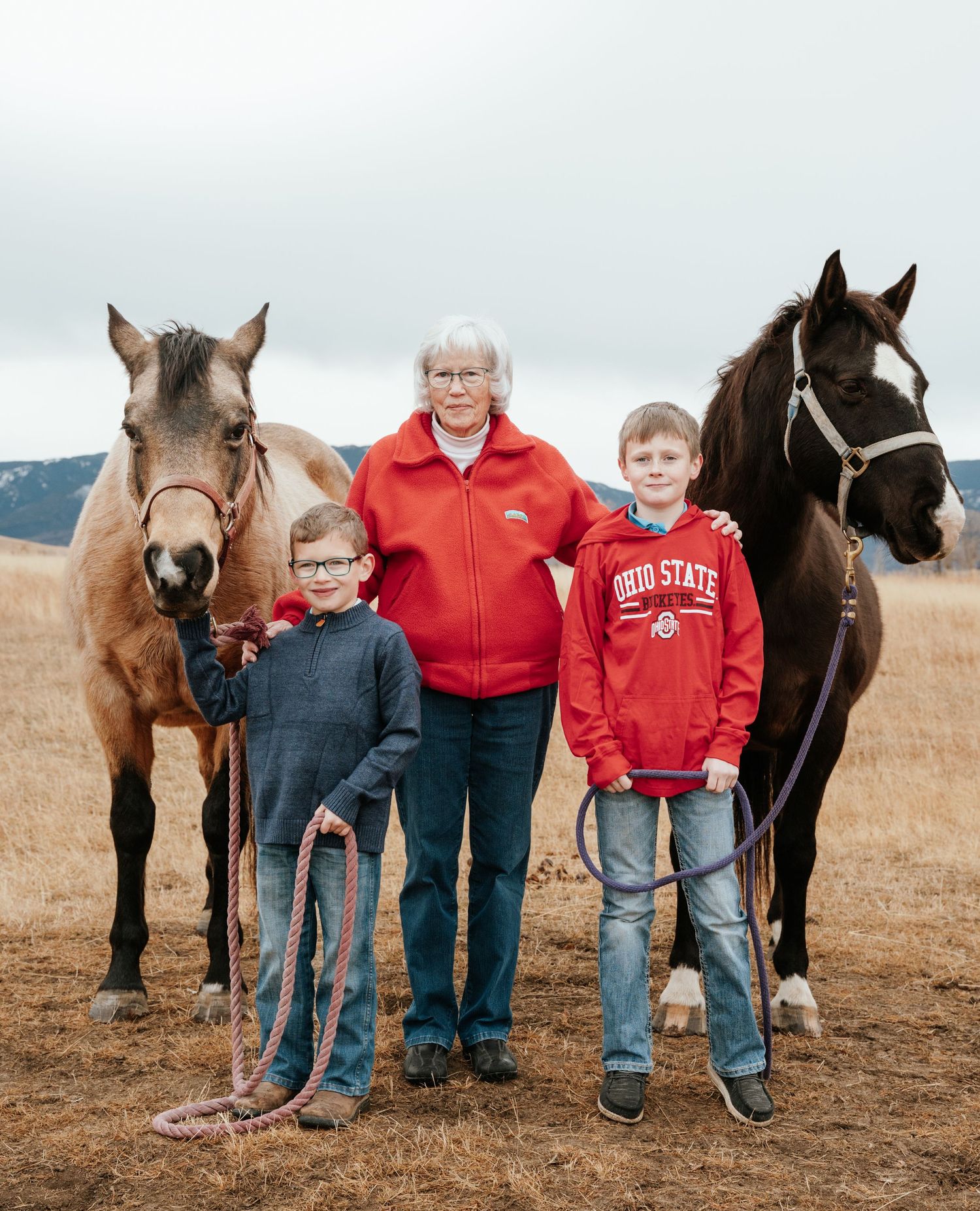 Partial family posing with horses.