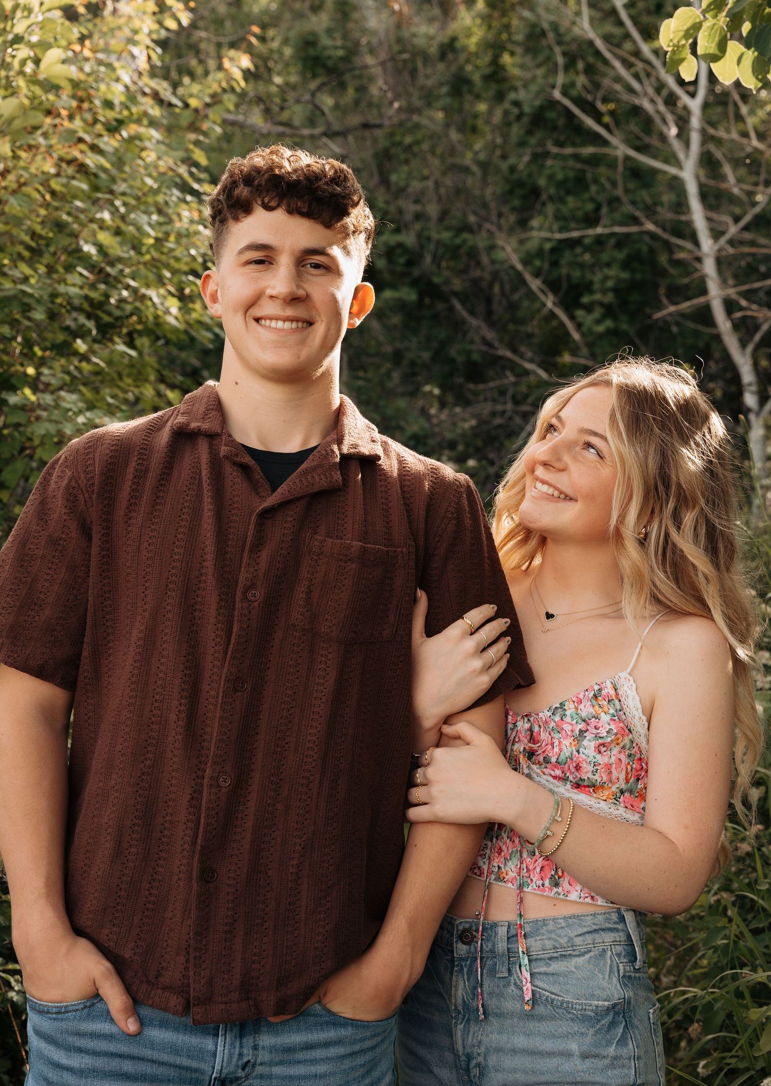 girlfriend looking at boyfriend while smiling and hugging his arm.
