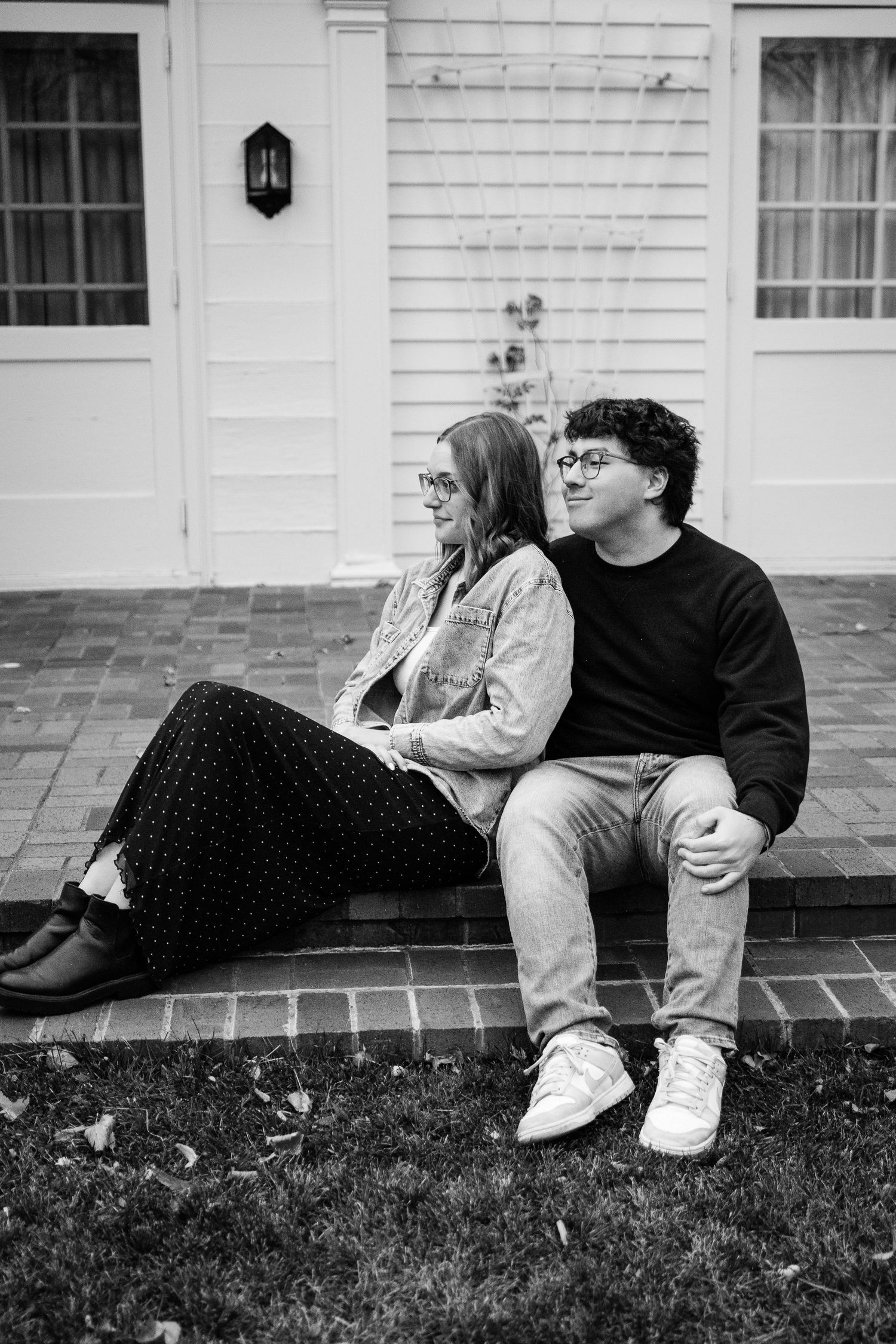 Girlfriend posing with boyfriend in front of house