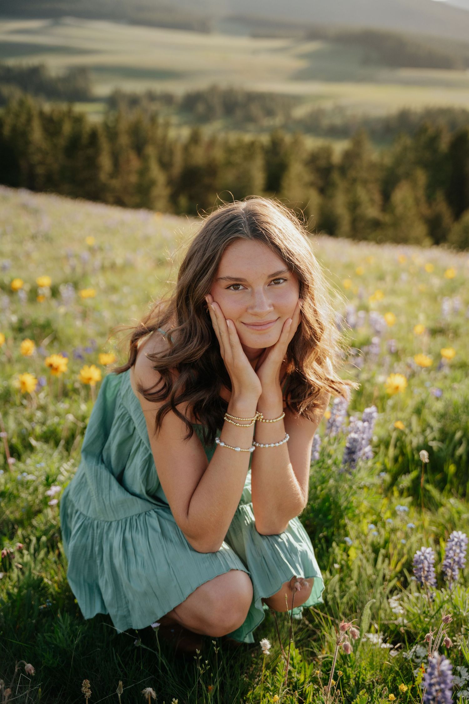 Girl sitting with her head in her hands in a flower field