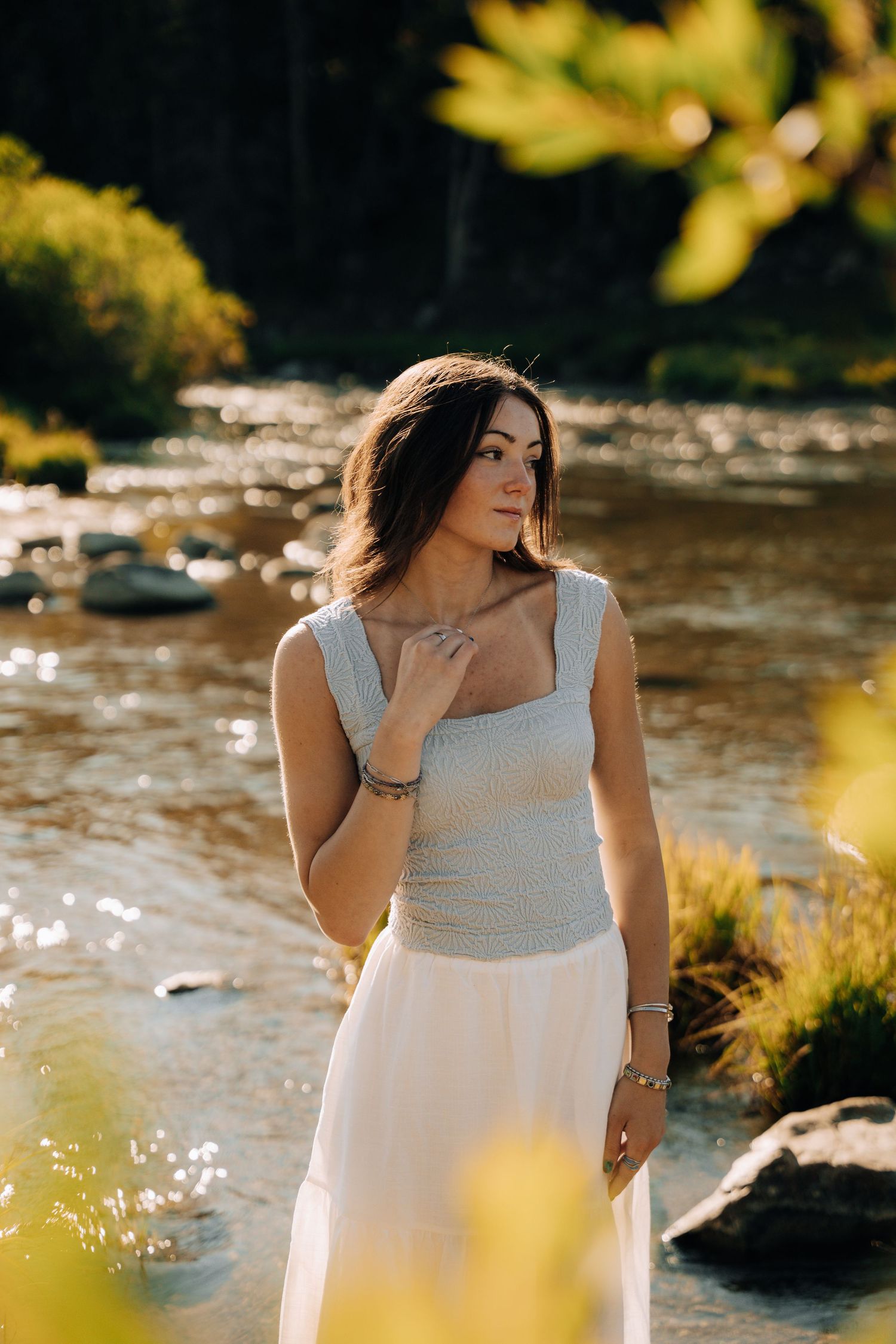 Womens senior session next to river while wearing flowy clothes