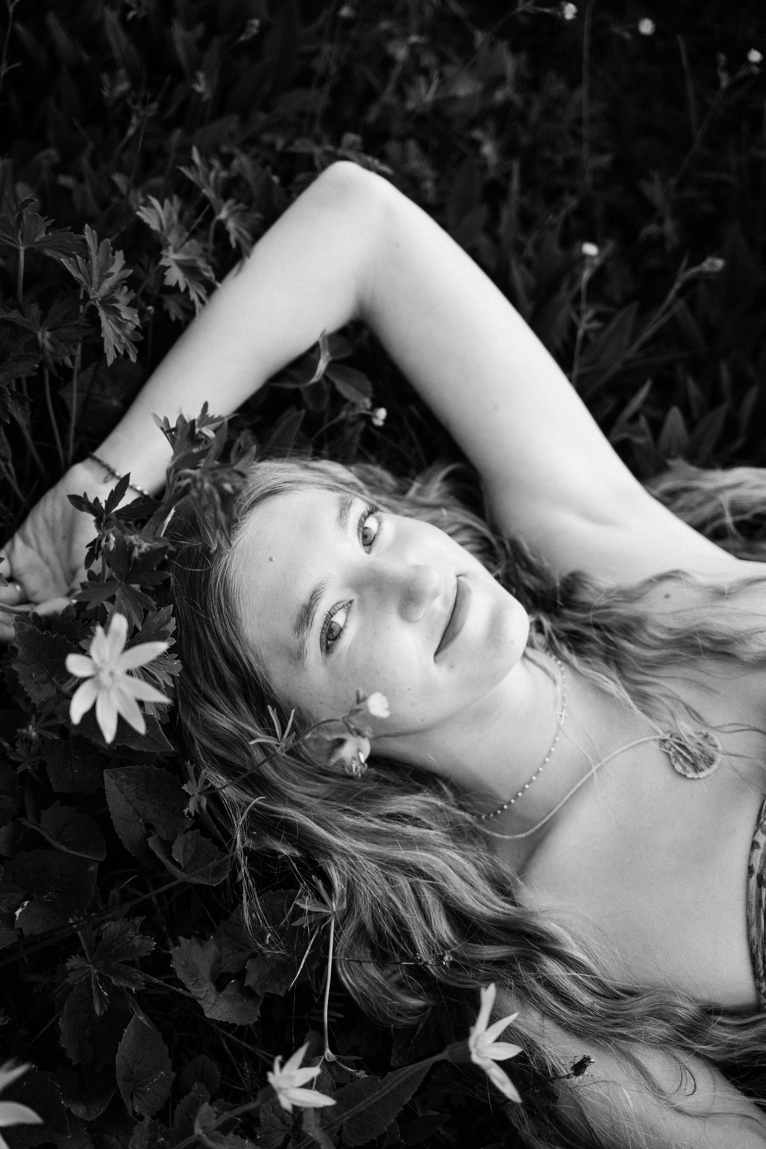 Senior laying on the ground looking up at the camera above.
