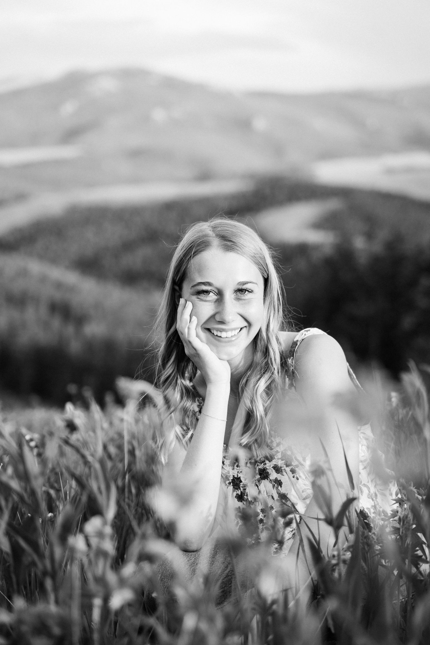 Girl looking into camera with her head propped in her hand.