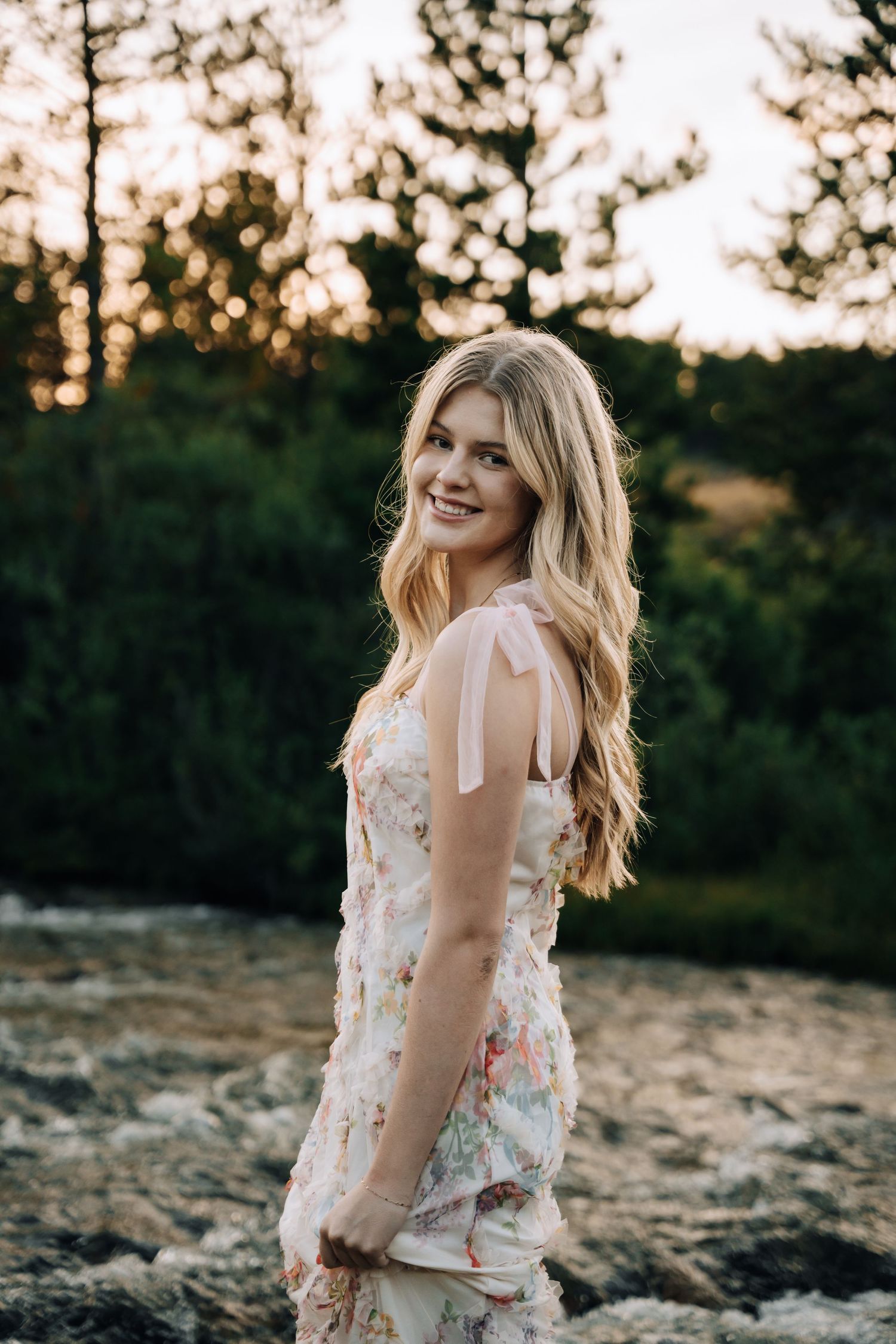 Girls Senior session in a river, wearing a dress.