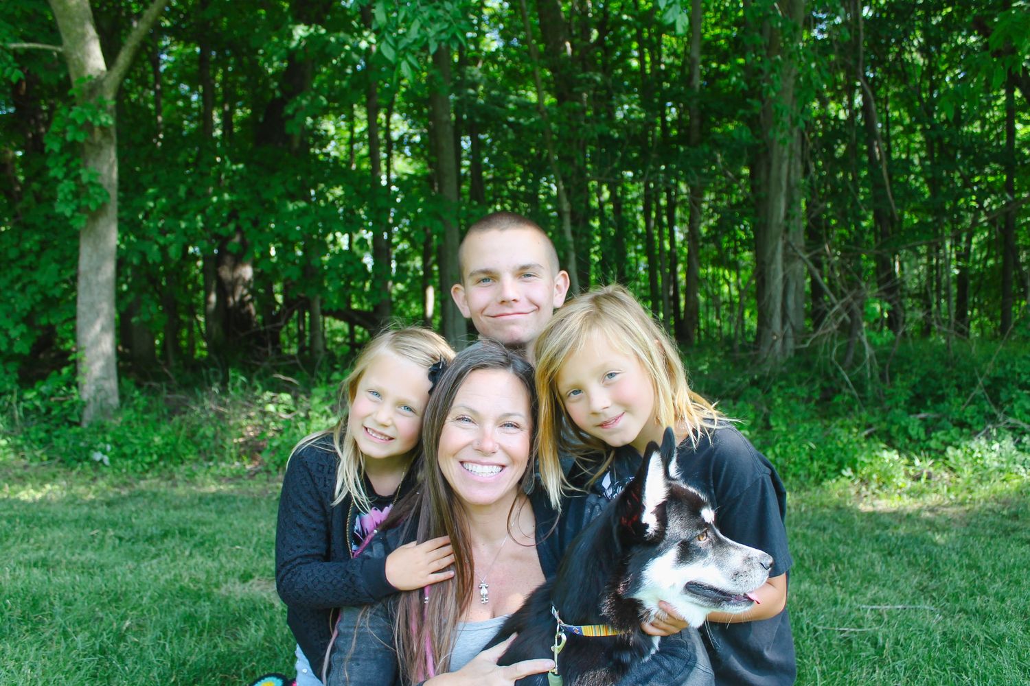 Group photo session in wooded area with pet dog.