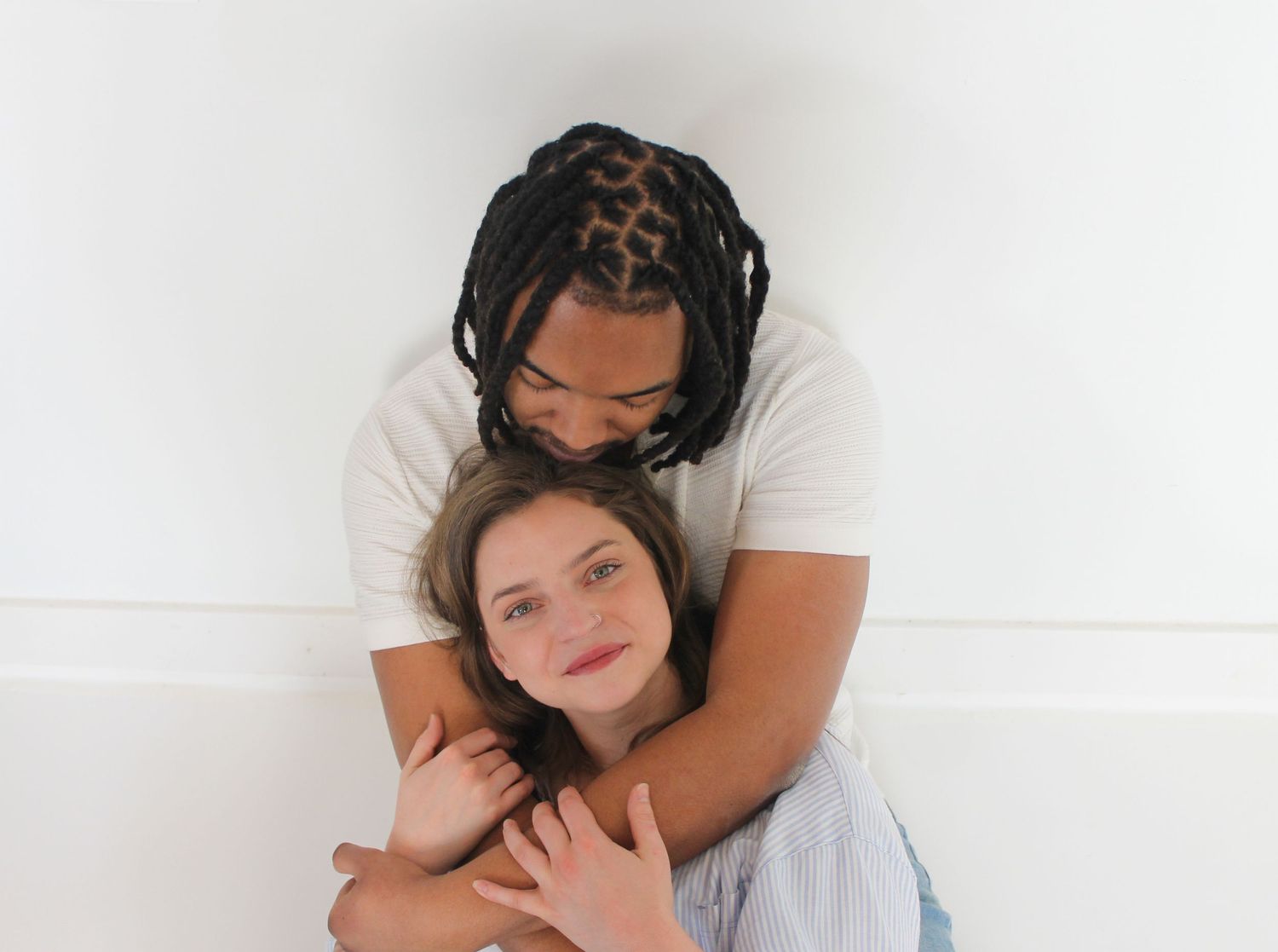 Two people sharing a tender embrace against a white background.