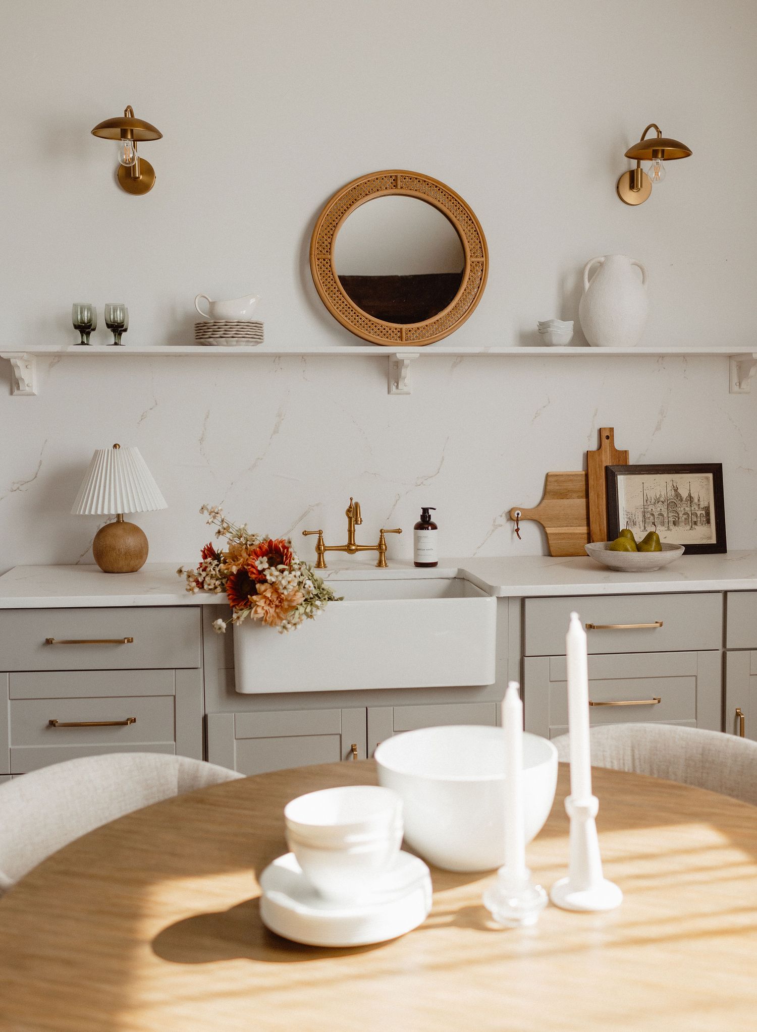 Minimalist white kitchen shelving with wooden accents and decorative items.