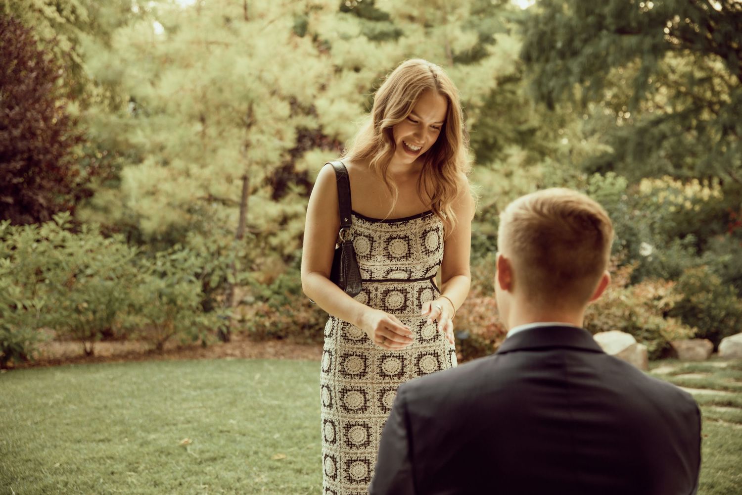 A romantic proposal moment in a lush garden setting.