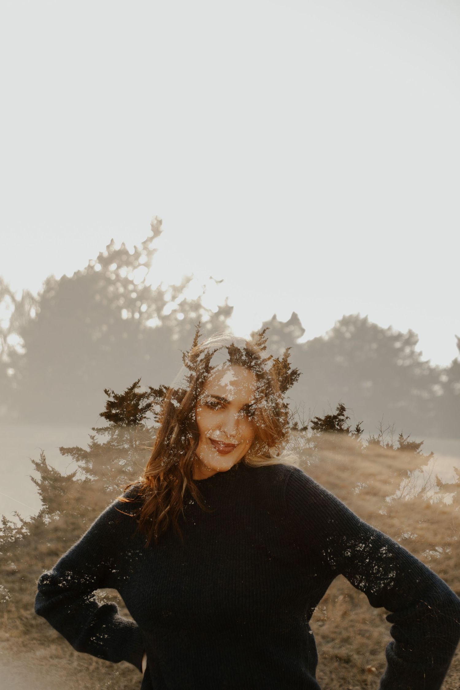 Artistic sunlit portrait with golden light and shadows creating a dreamy outdoor atmosphere.