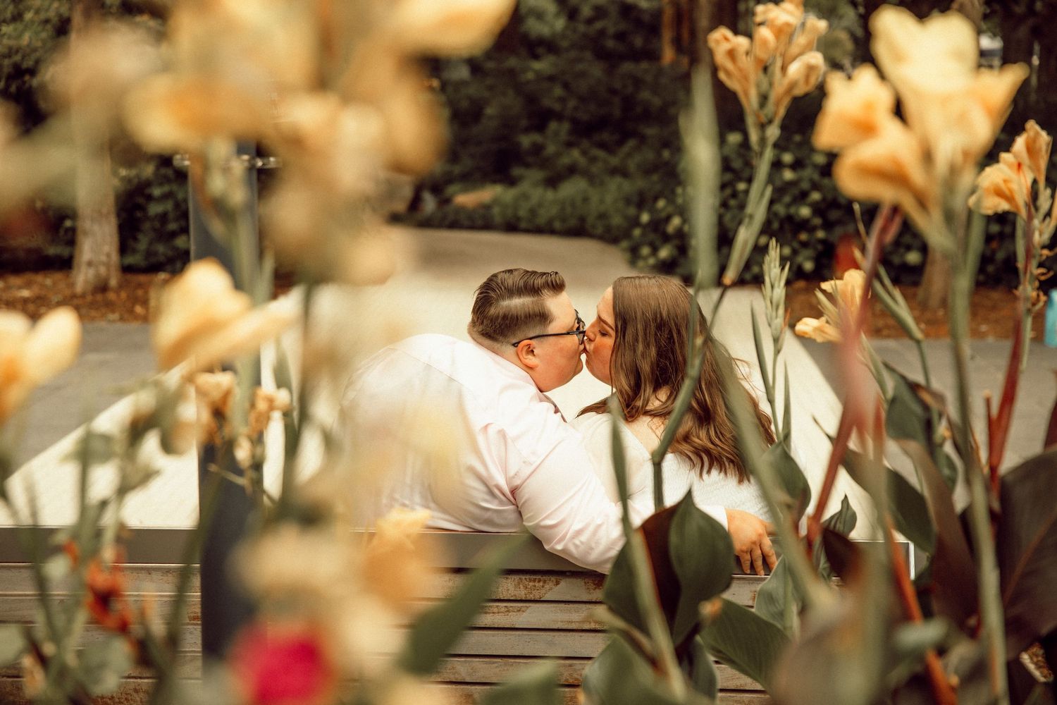 A romantic moment captured through blooming flowers in a garden setting.
