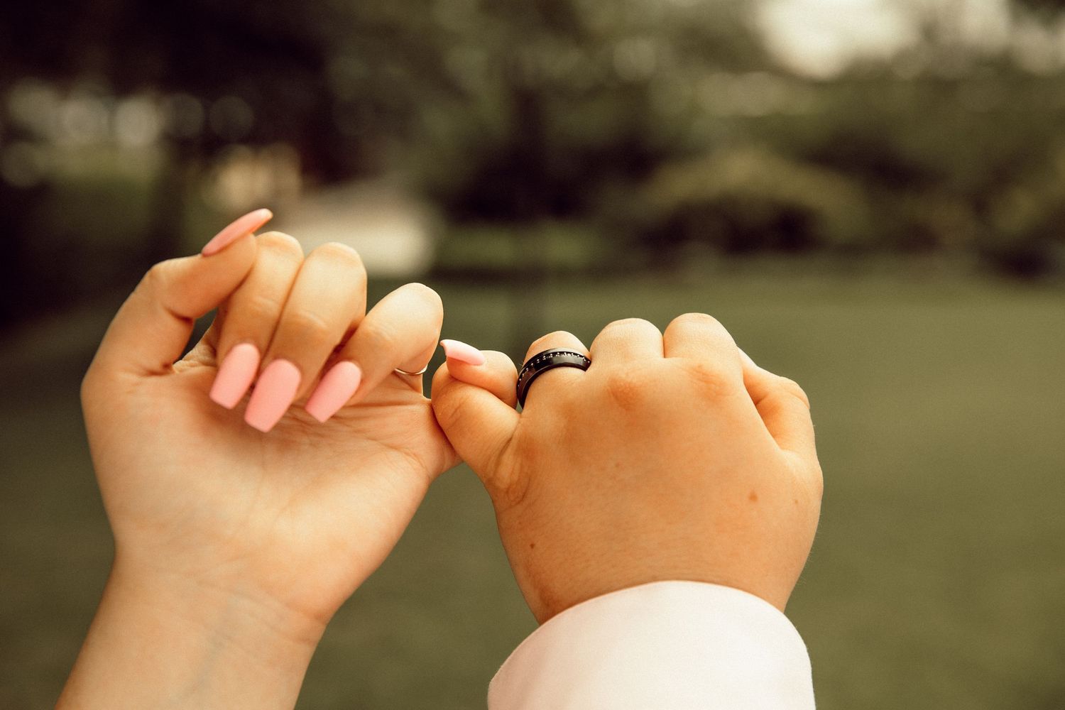 Close-up of hands holding a ring during a proposal moment.