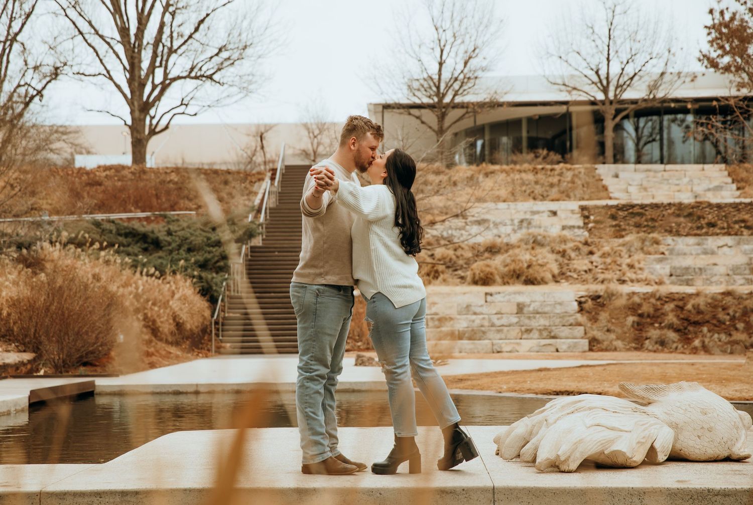 Couple strolls together on stone path during winter engagement session.