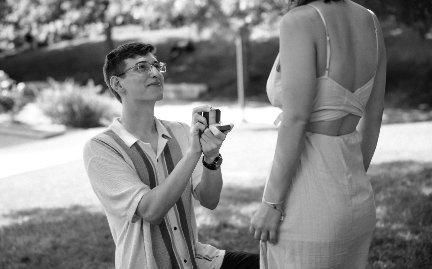 A black and white photo capturing a tender pregnancy announcement moment.