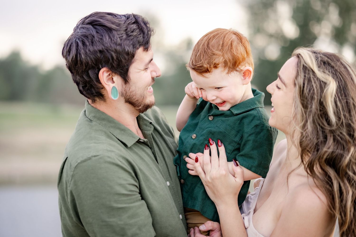 Sweet family moment captured by lake during outdoor photoshoot. A family portrait by Helena photographer Kelsea Laine Photography.