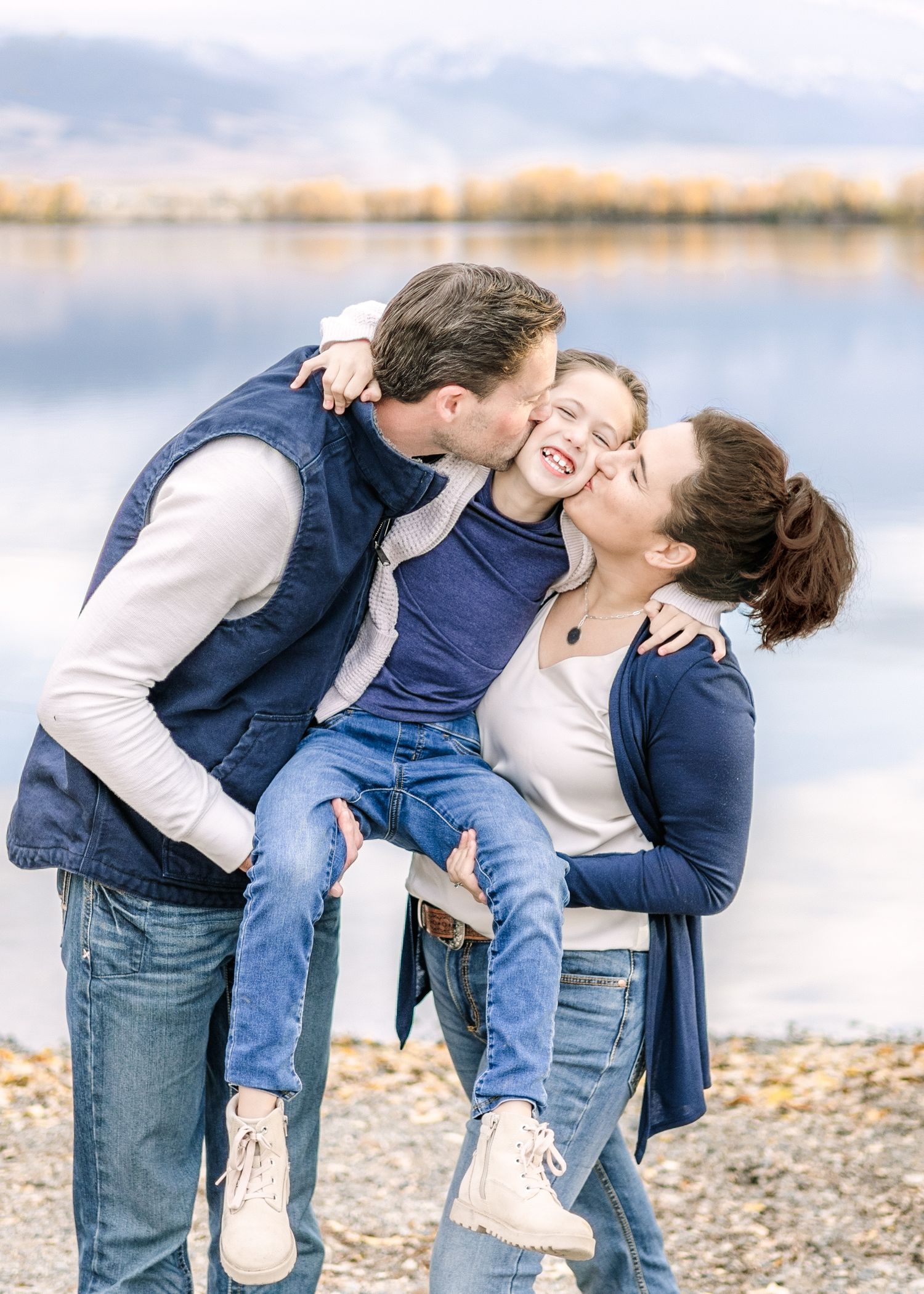 A Montana wedding photographer and her husband share playful moment with their daughter at a lake in Helena.