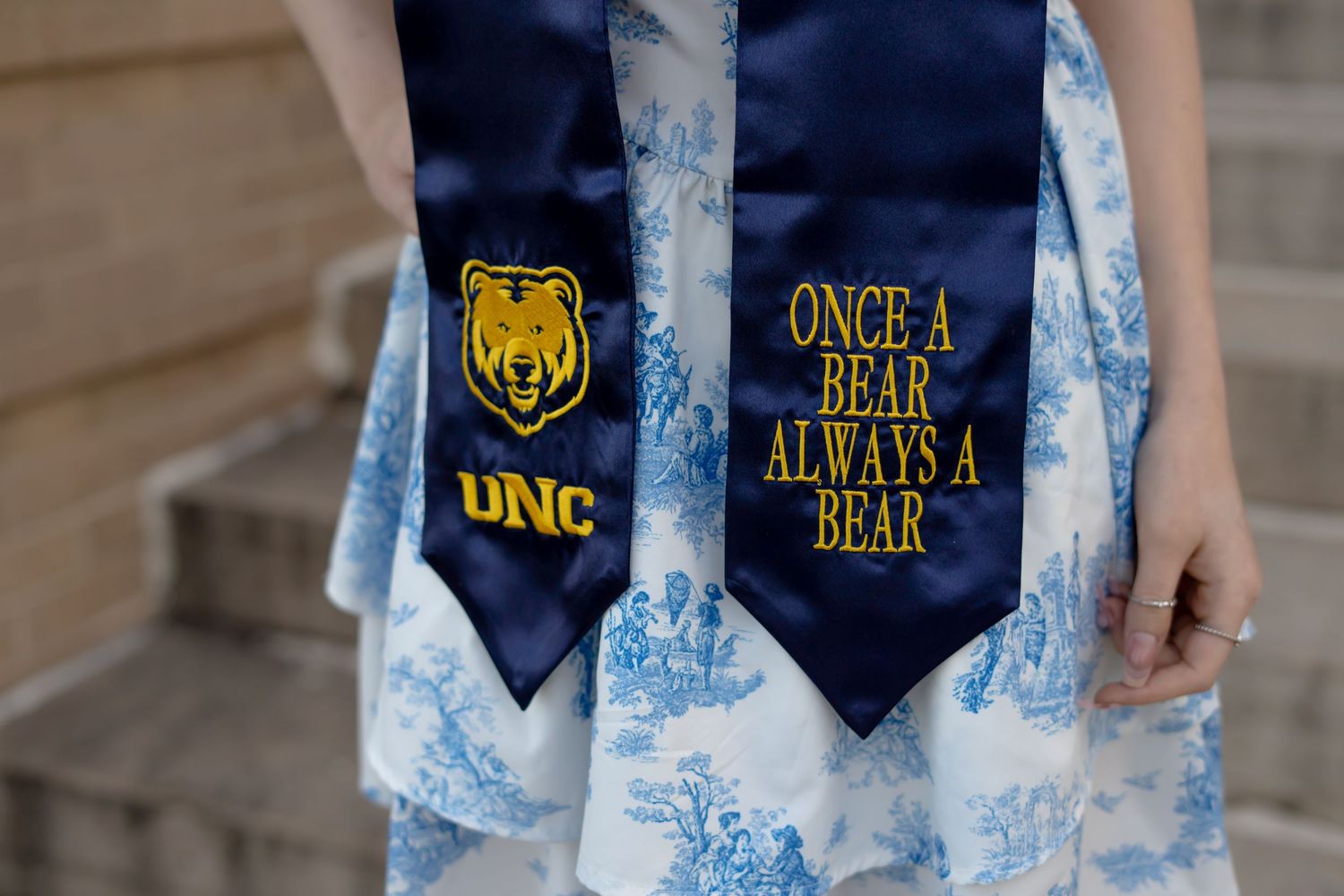 Navy graduation stoles with gold lettering showing 'Once a Bear' text.