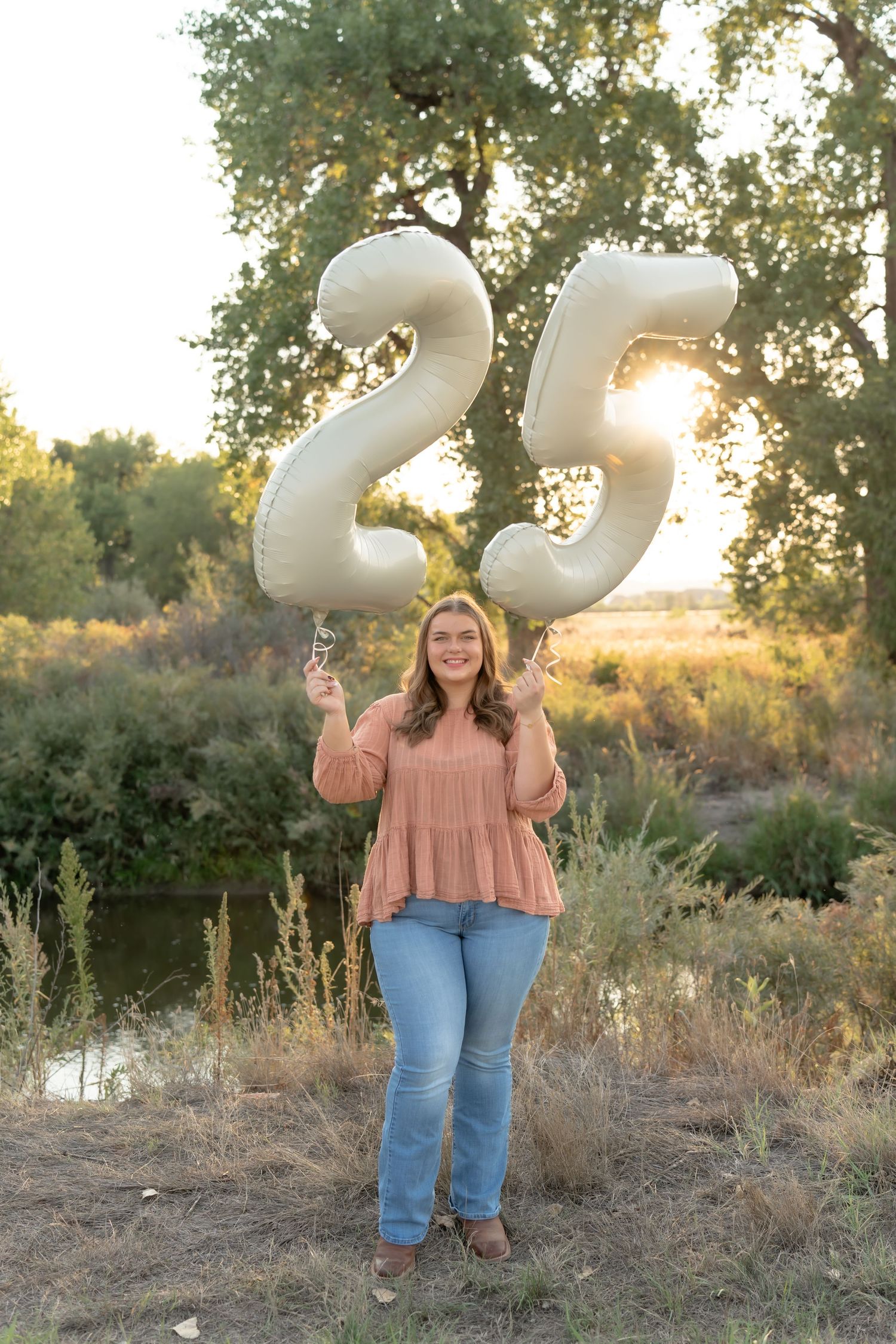 Senior graduation celebration photos with white number balloons in a natural outdoor setting.