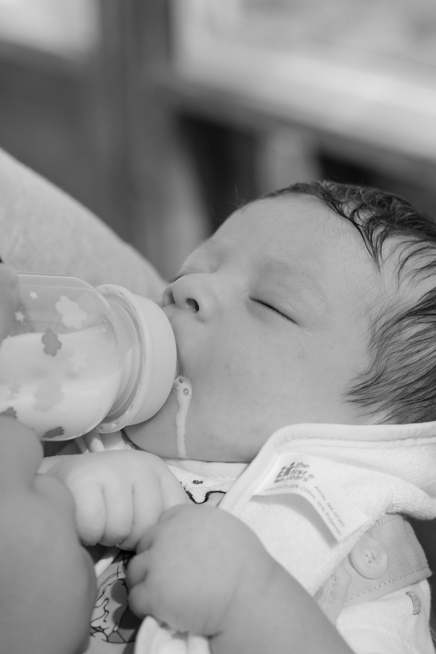 Black and white image showing a sleeping newborn with medical tubes.