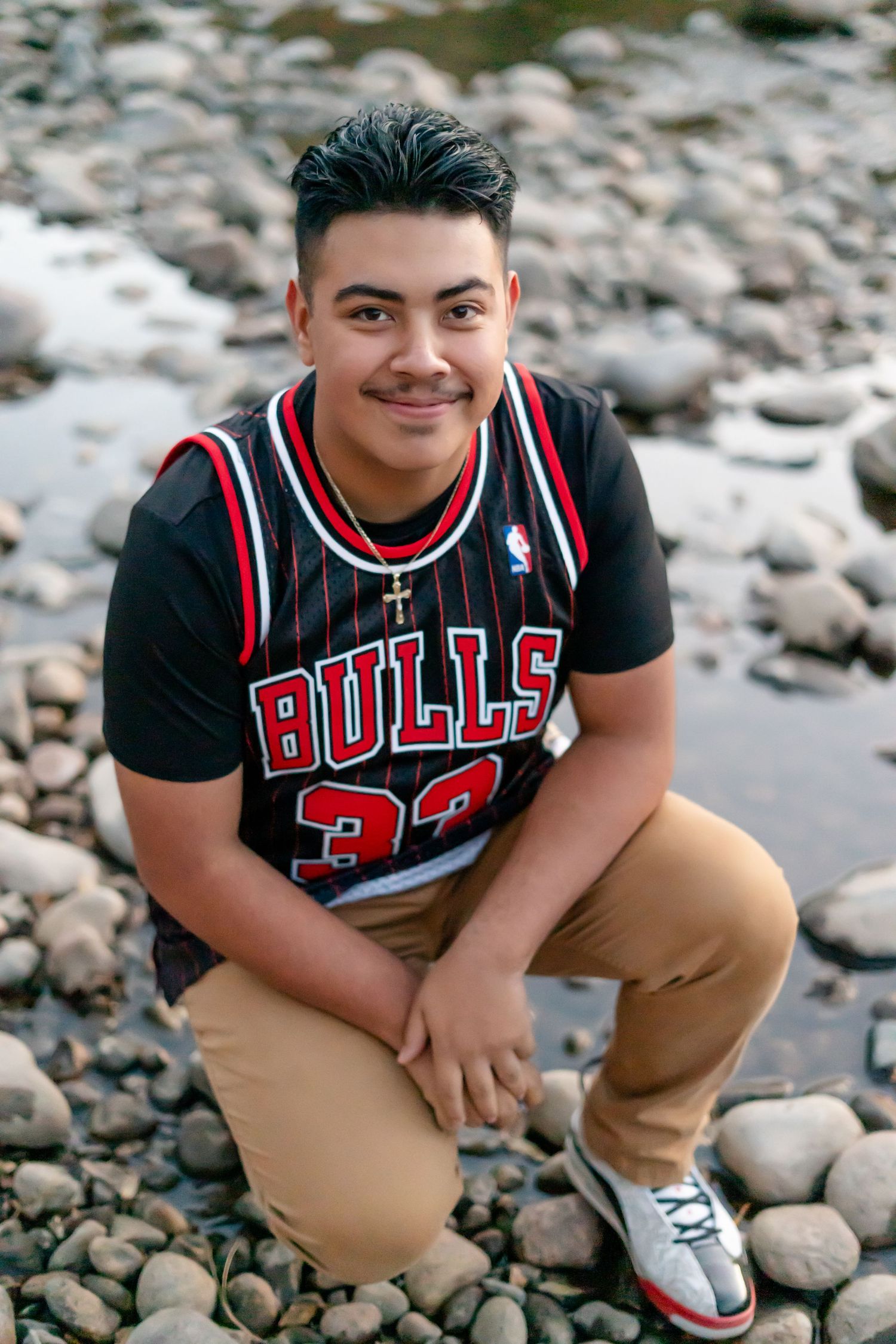 A series of casual portraits featuring someone wearing a Chicago Bulls jersey and khaki pants on a rocky background.